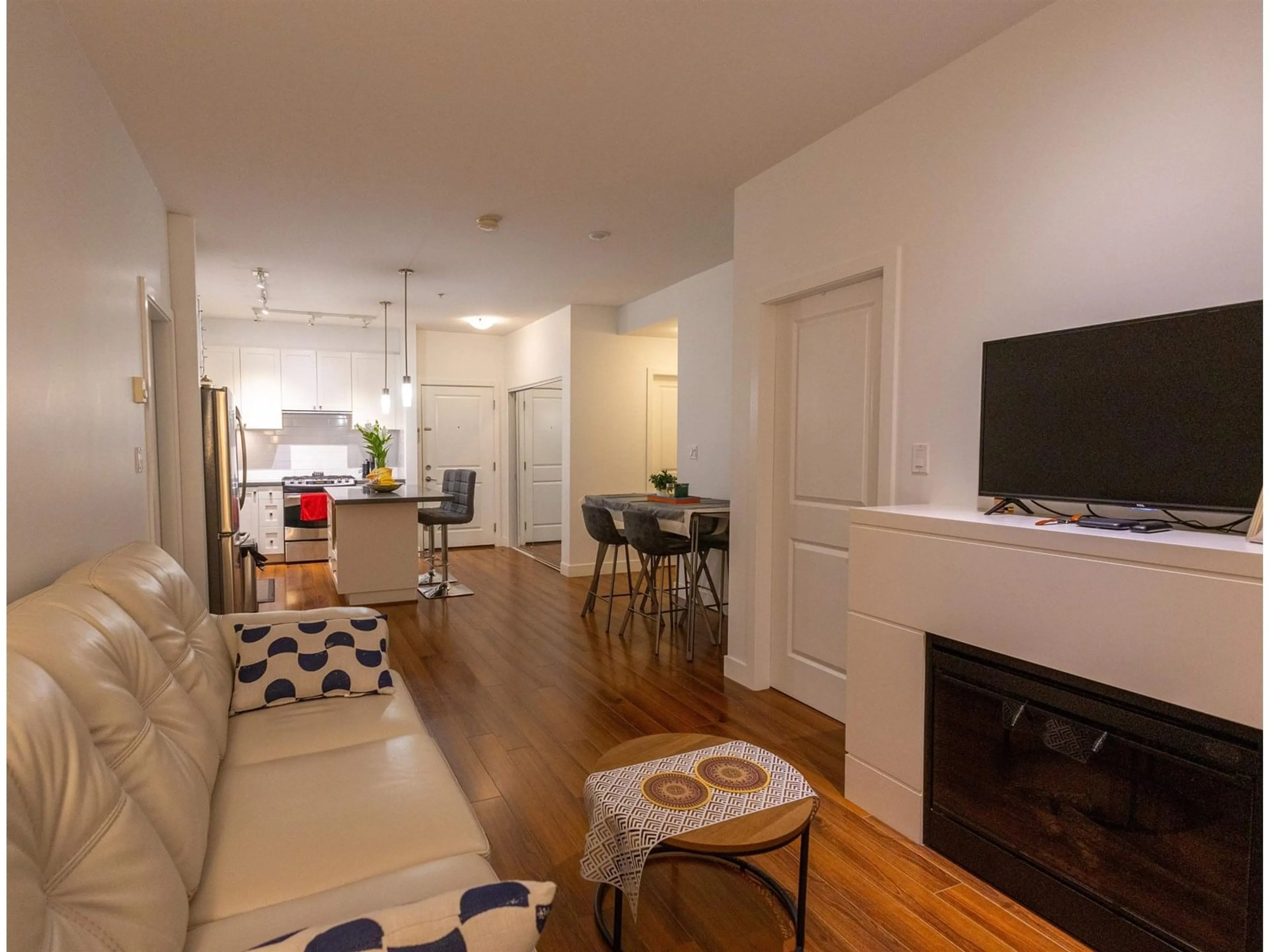 Living room with furniture, wood/laminate floor for 305 - 15850 26, Surrey British Columbia V3Z2N6