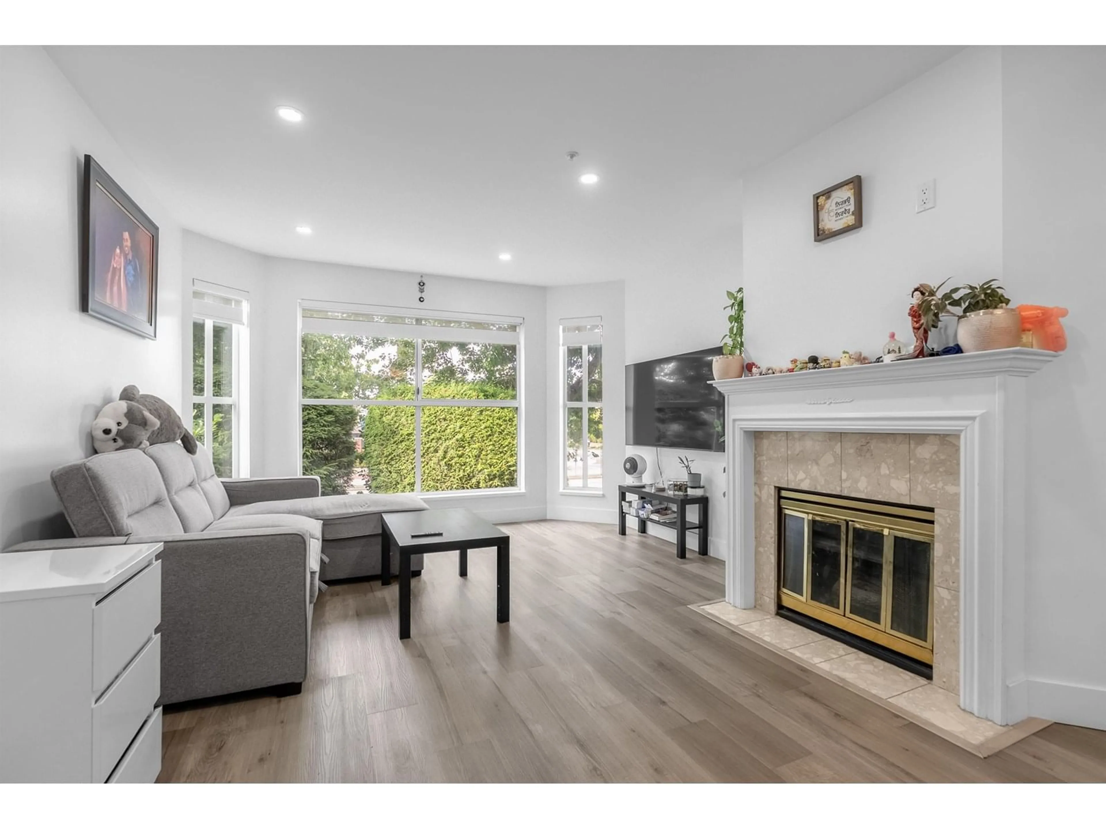 Living room with furniture, wood/laminate floor for 210 - 7171 121, Surrey British Columbia V3W1G9