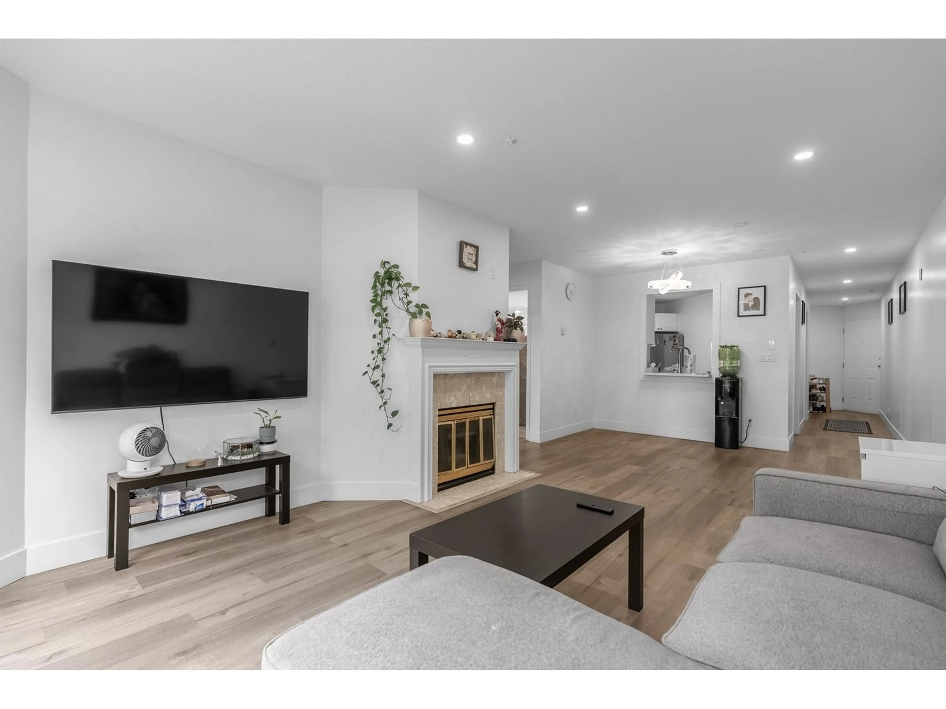Living room with furniture, wood/laminate floor for 210 - 7171 121, Surrey British Columbia V3W1G9