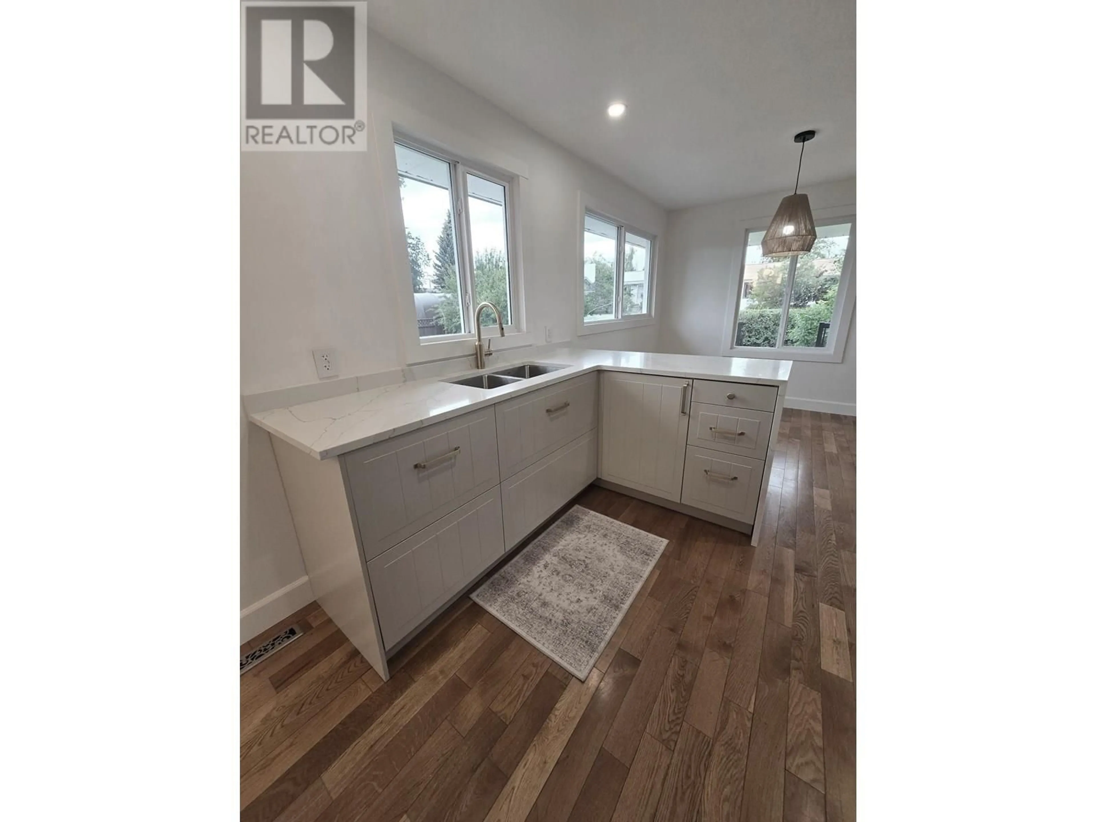 Open concept kitchen, wood/laminate floor for 10307 104 AVENUE, Fort St. John British Columbia V1J2K8