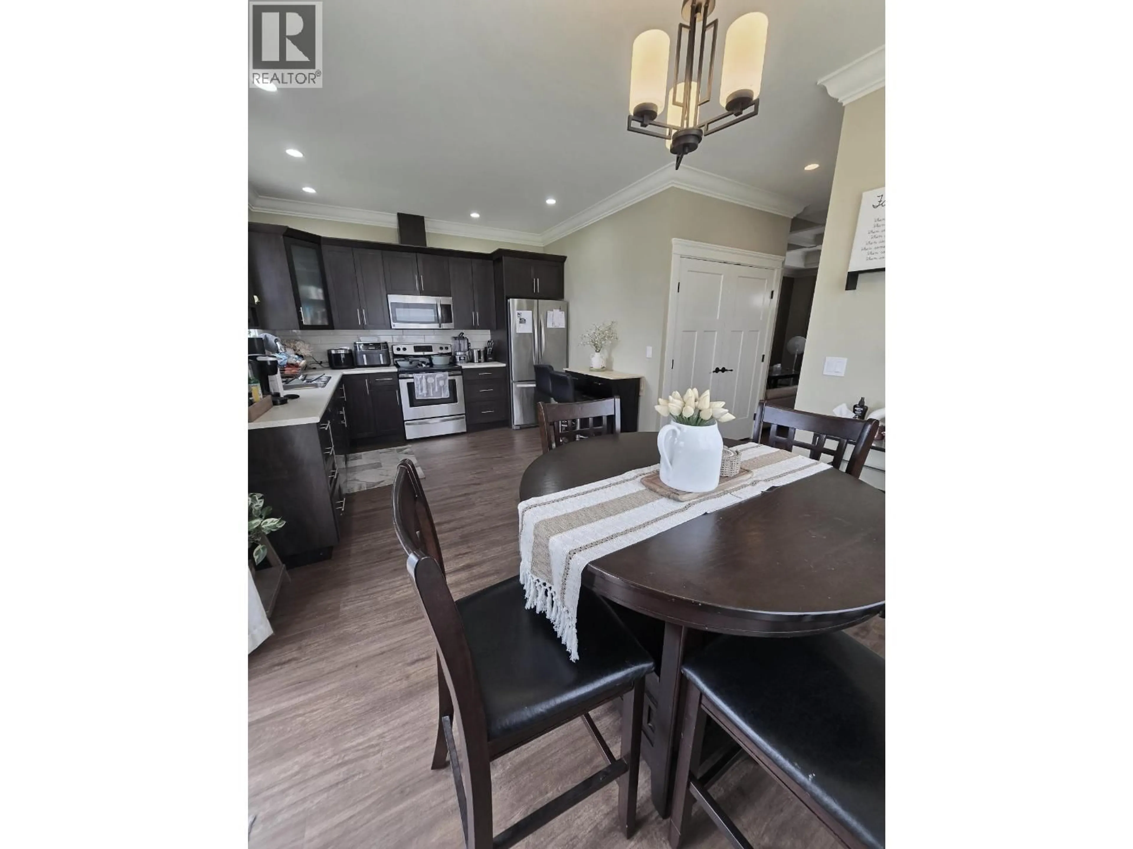 Open concept kitchen, wood/laminate floor for 8817 90 STREET, Fort St. John British Columbia V1J4K3