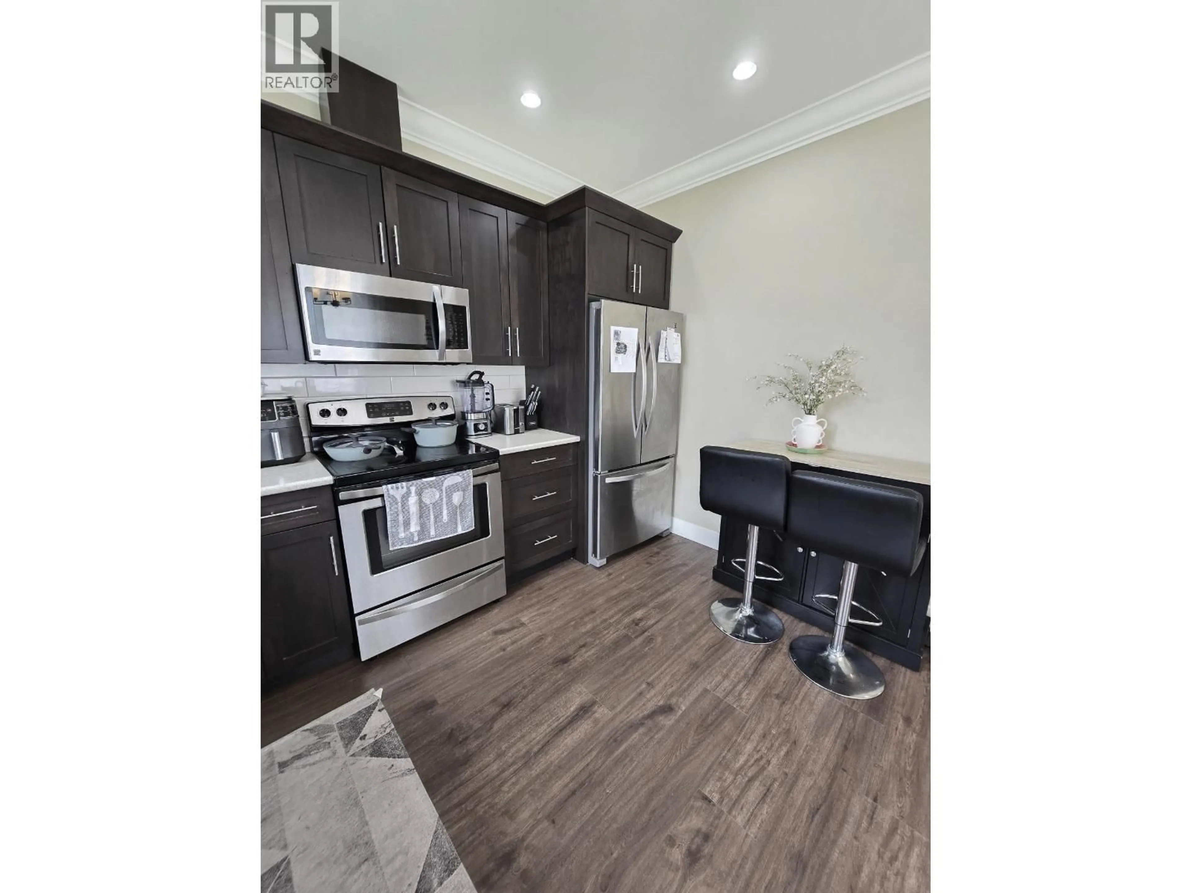 Open concept kitchen, wood/laminate floor for 8817 90 STREET, Fort St. John British Columbia V1J4K3