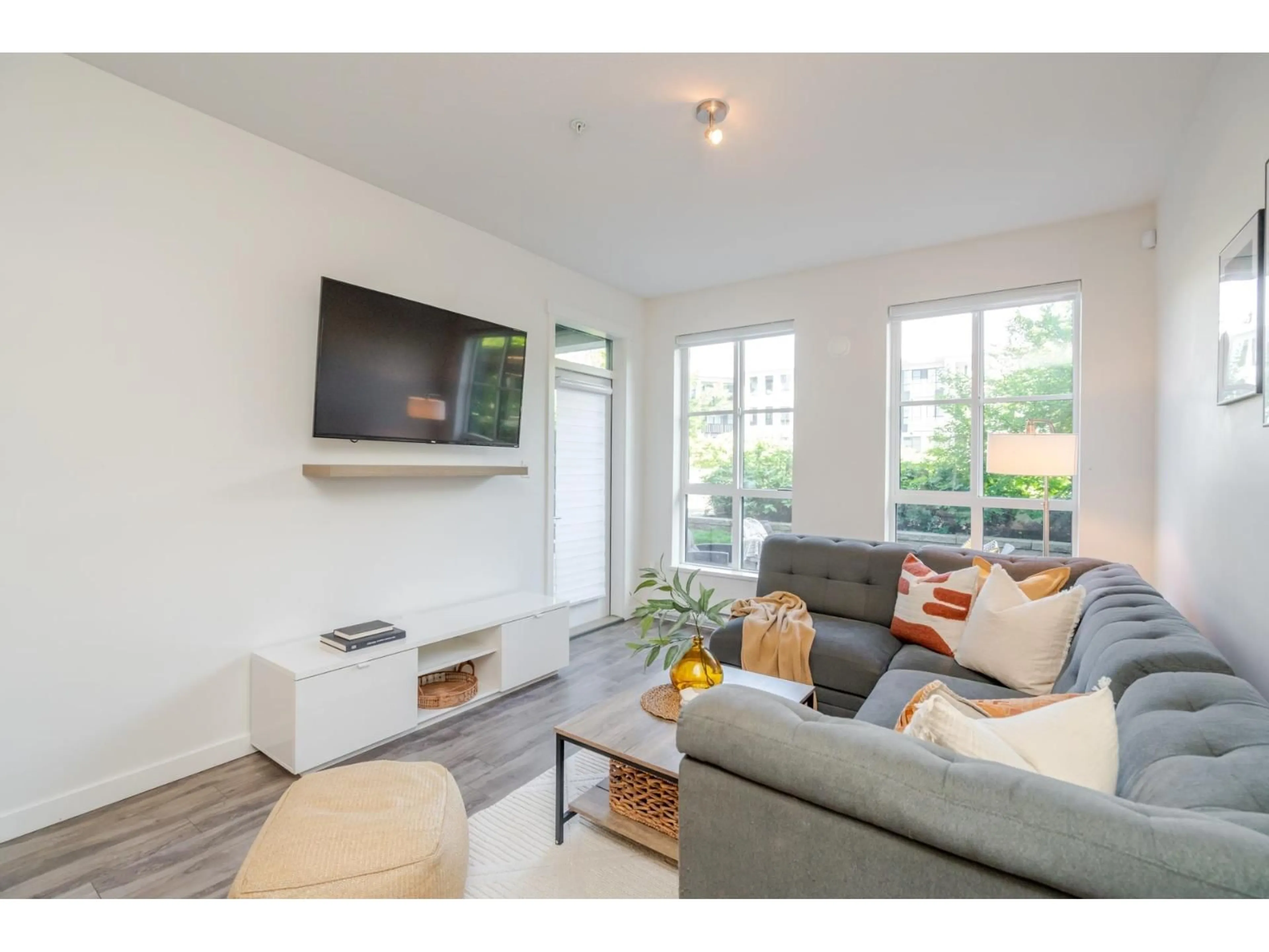 Living room with furniture, wood/laminate floor for 101 - 15137 33, Surrey British Columbia V3Z0Y1