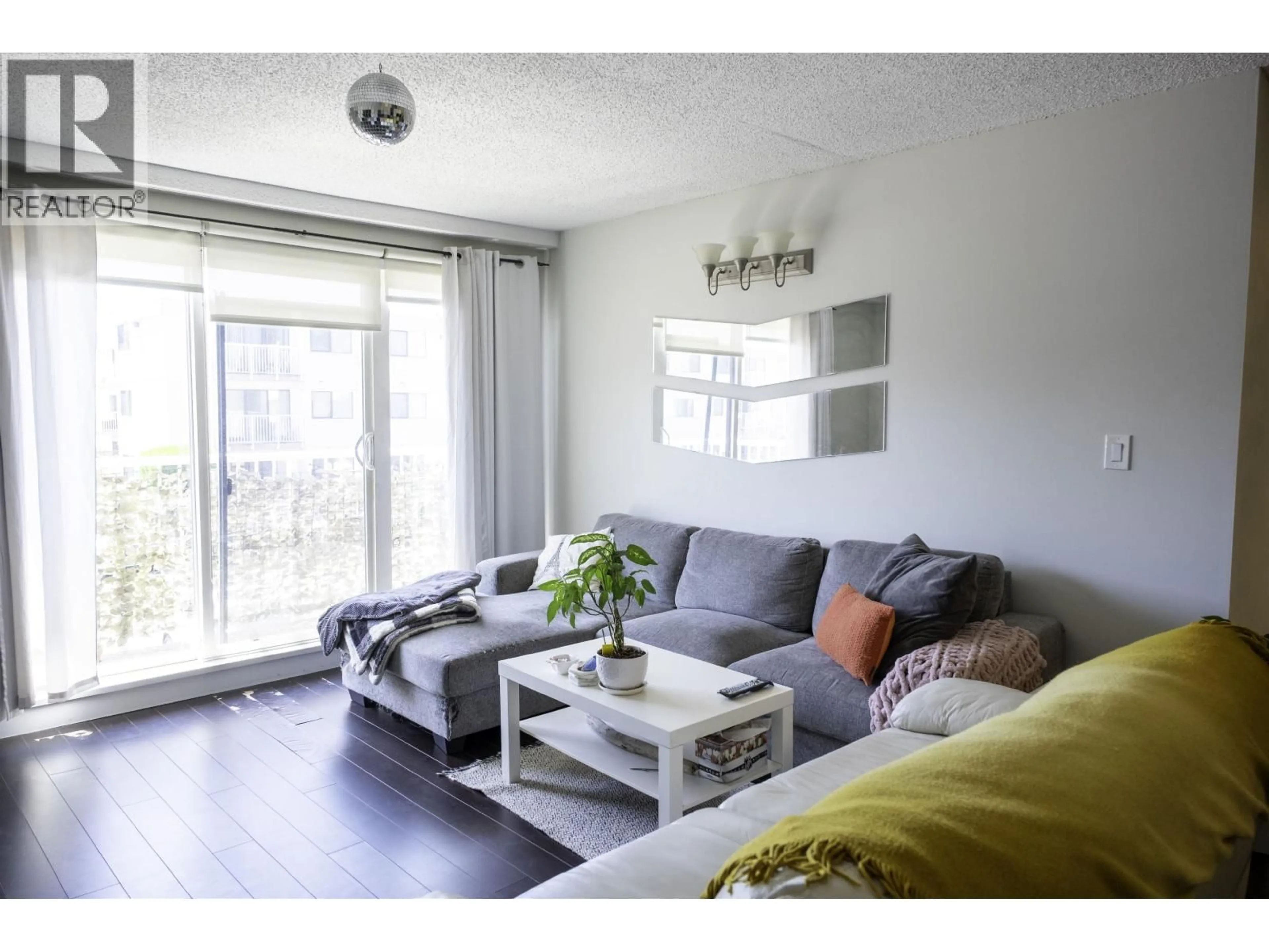 Living room with furniture, wood/laminate floor for 205 - 7180 LINDSAY ROAD, Richmond British Columbia V7C3M6