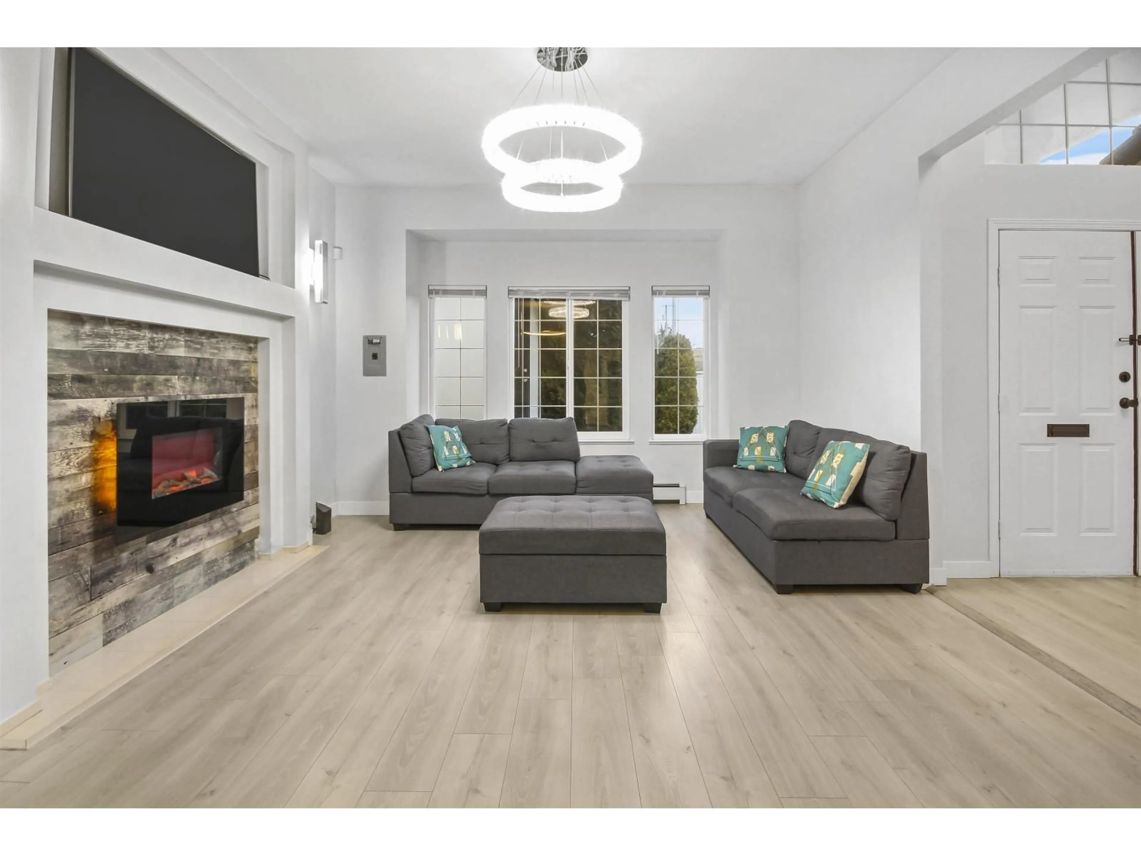 Living room with furniture, wood/laminate floor for 8213 152, Surrey British Columbia V3S3M6