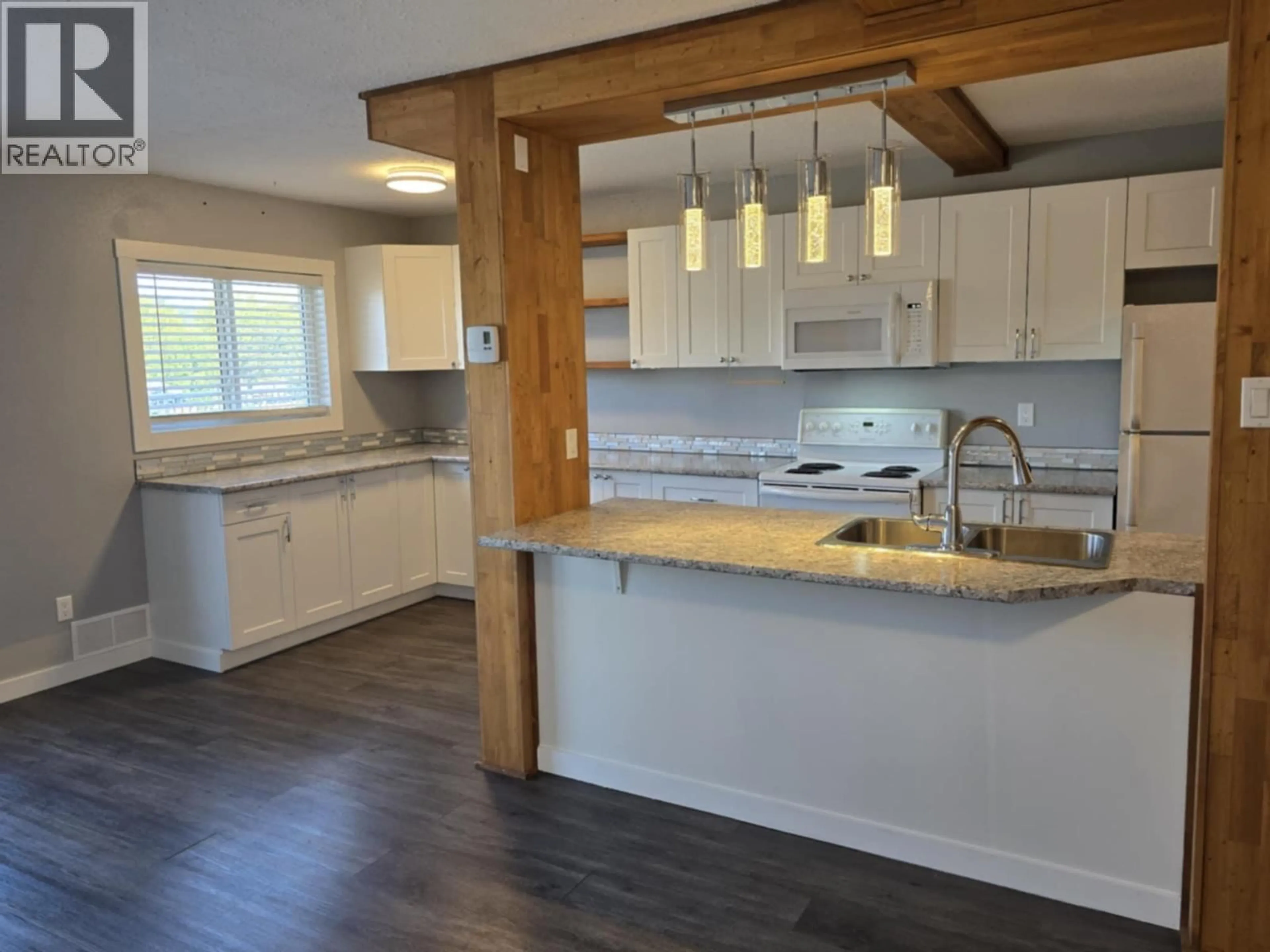 Open concept kitchen, wood/laminate floor for 101 - 625 REID STREET, Quesnel British Columbia V2J2N2