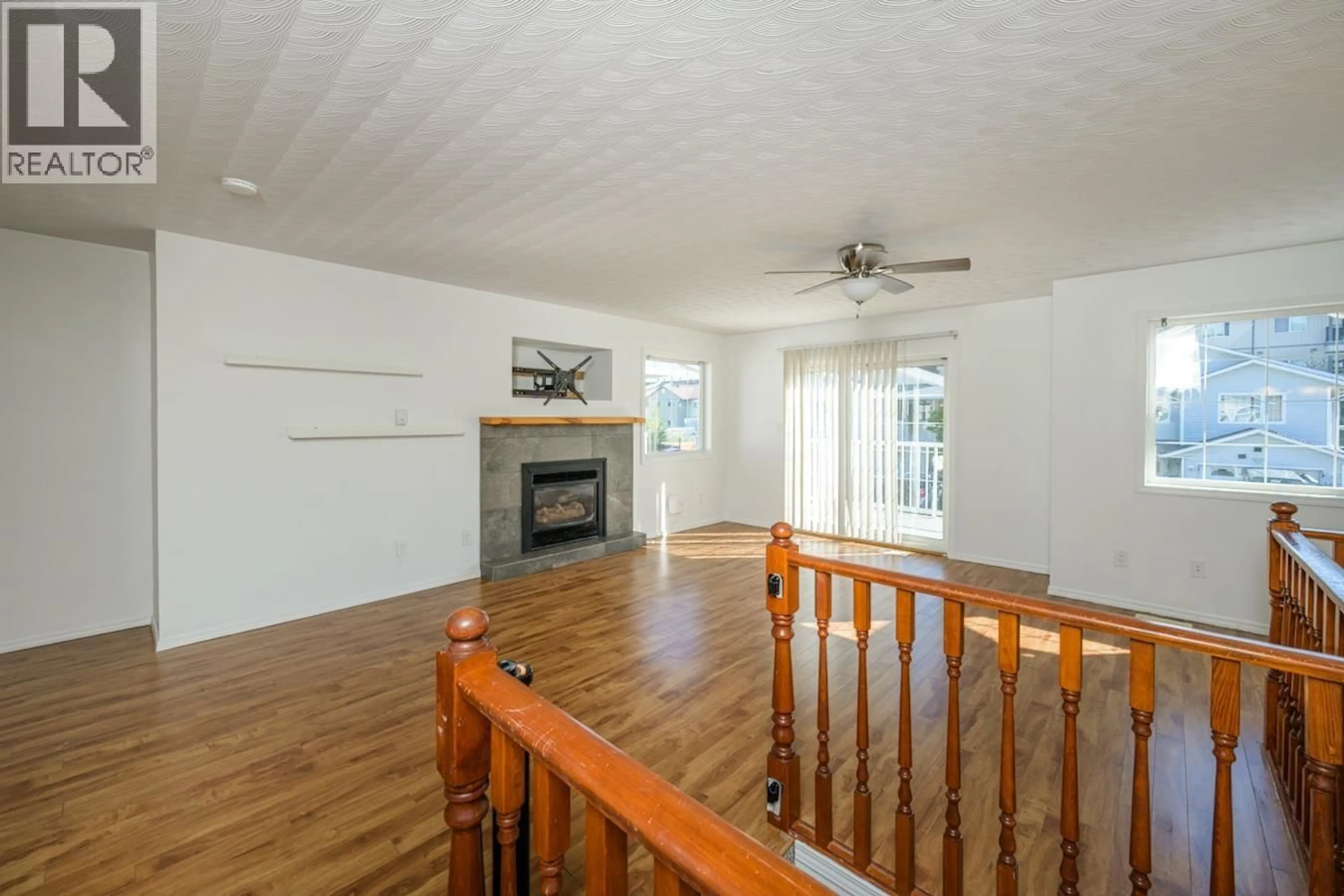 Living room with furniture, wood/laminate floor for 102 - 3308 UNDERHILL ROAD, Prince George British Columbia V2N1W5