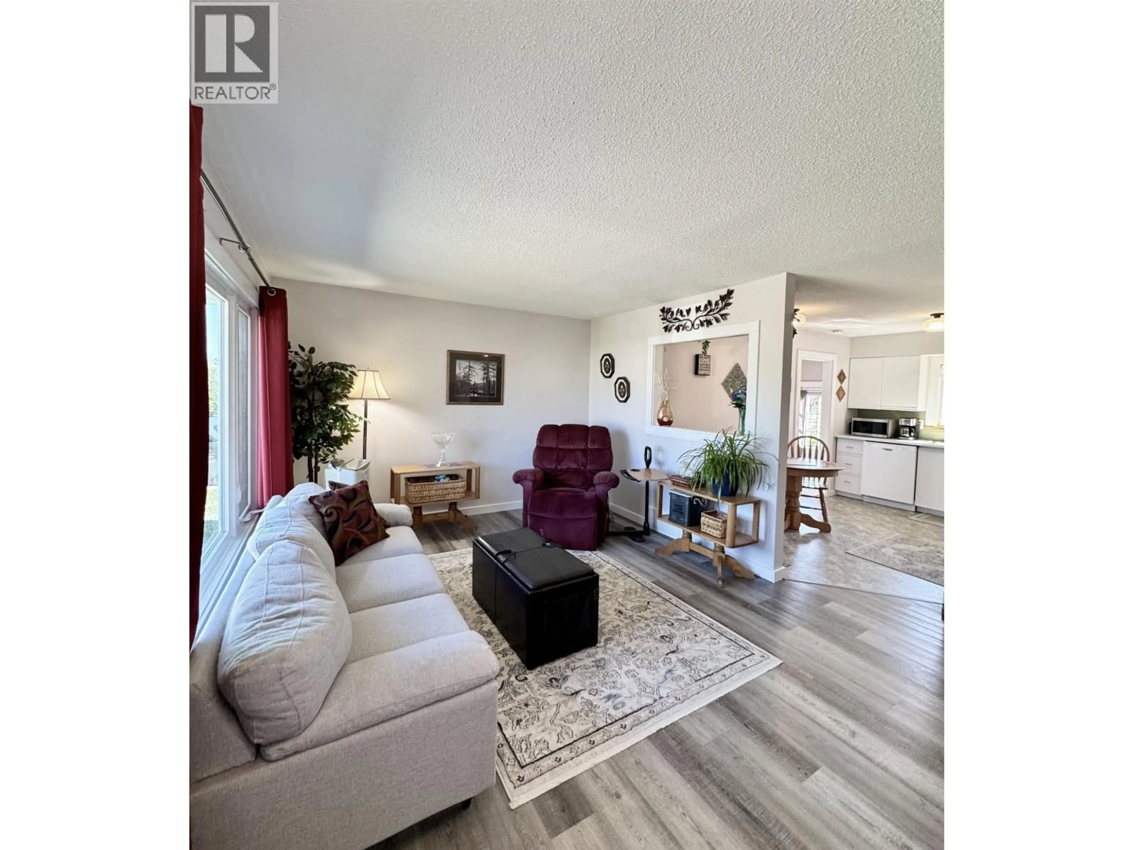 Living room with furniture, wood/laminate floor for 8219 98 AVENUE, Fort St. John British Columbia V1J1P4