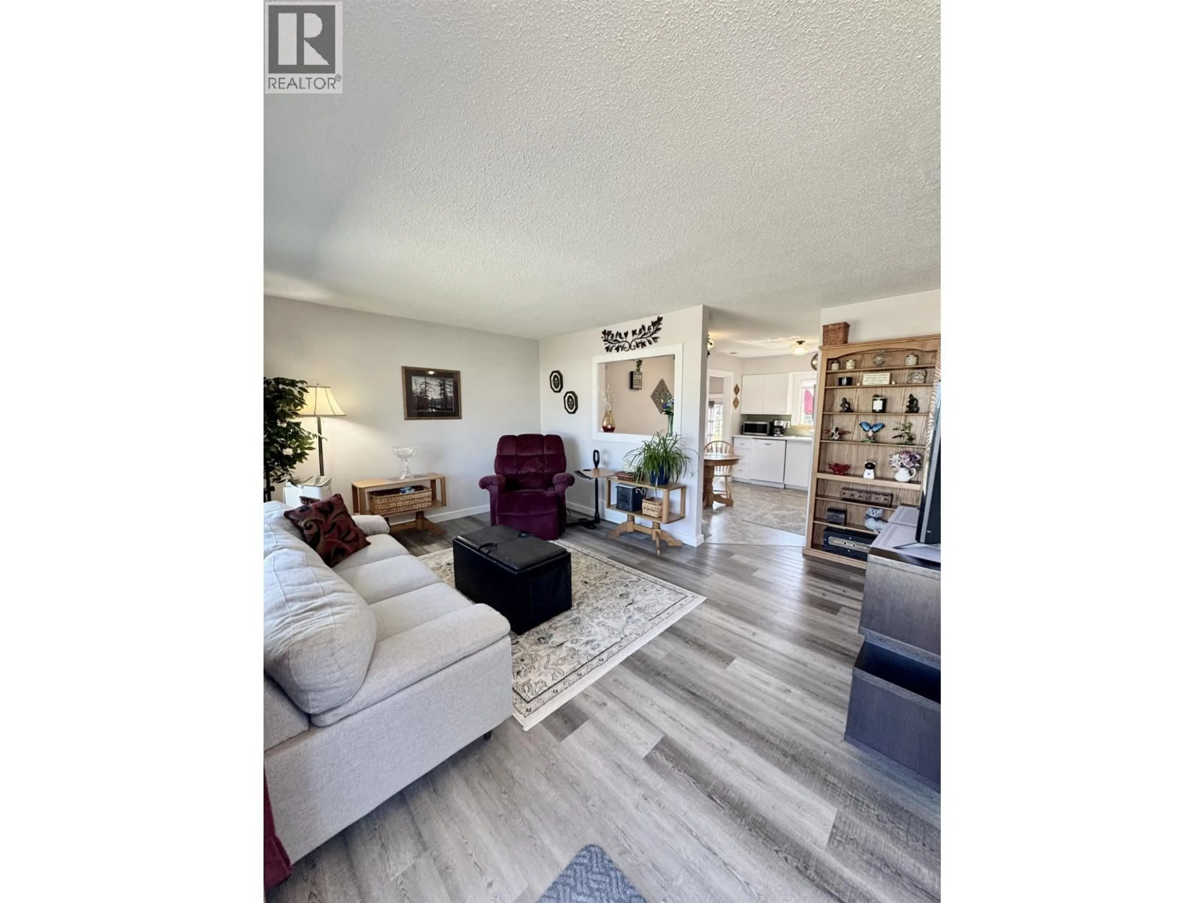 Living room with furniture, wood/laminate floor for 8219 98 AVENUE, Fort St. John British Columbia V1J1P4
