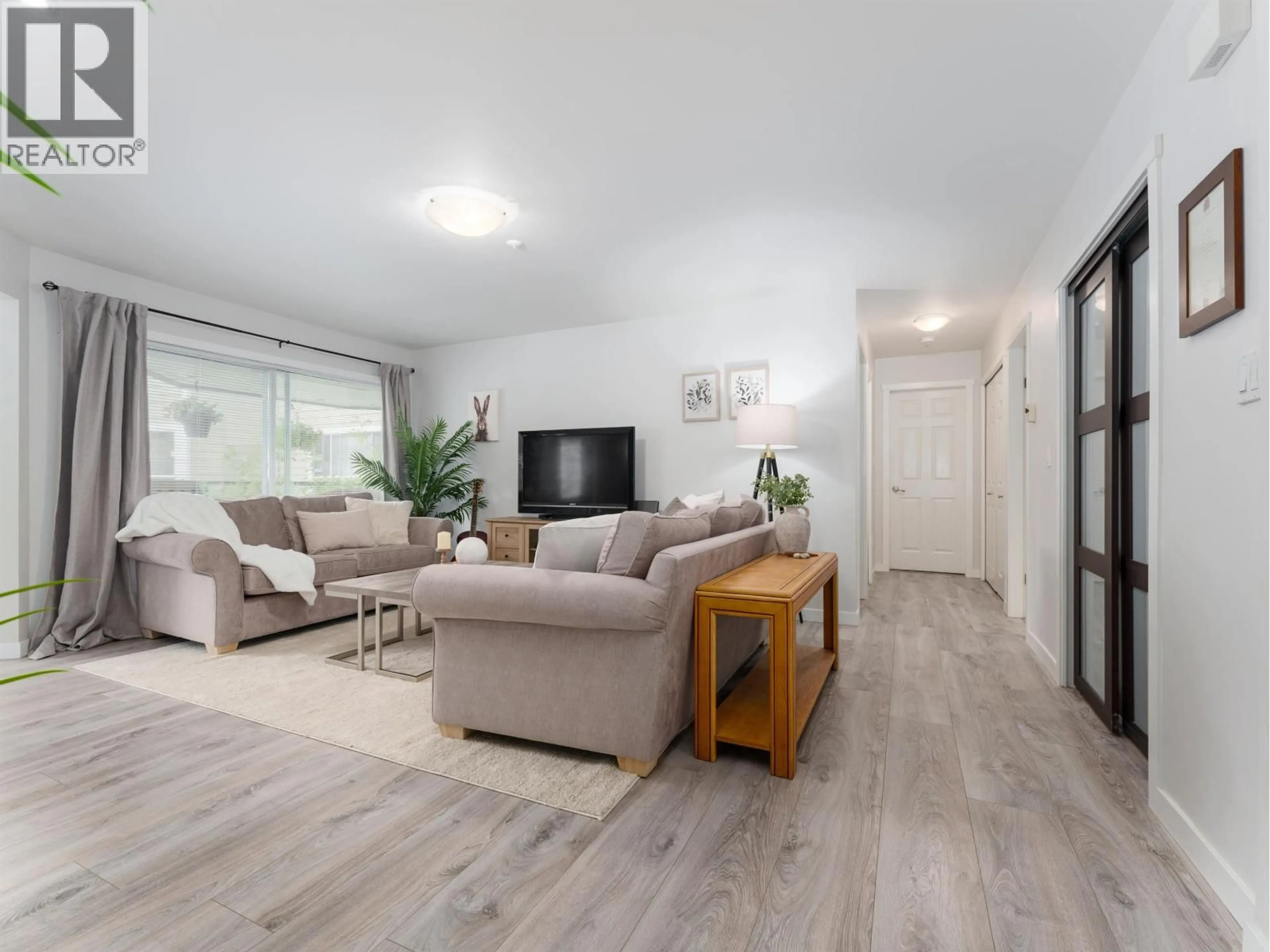 Living room with furniture, wood/laminate floor for 212 - 3690 BANFF COURT, North Vancouver British Columbia V7H2Y7