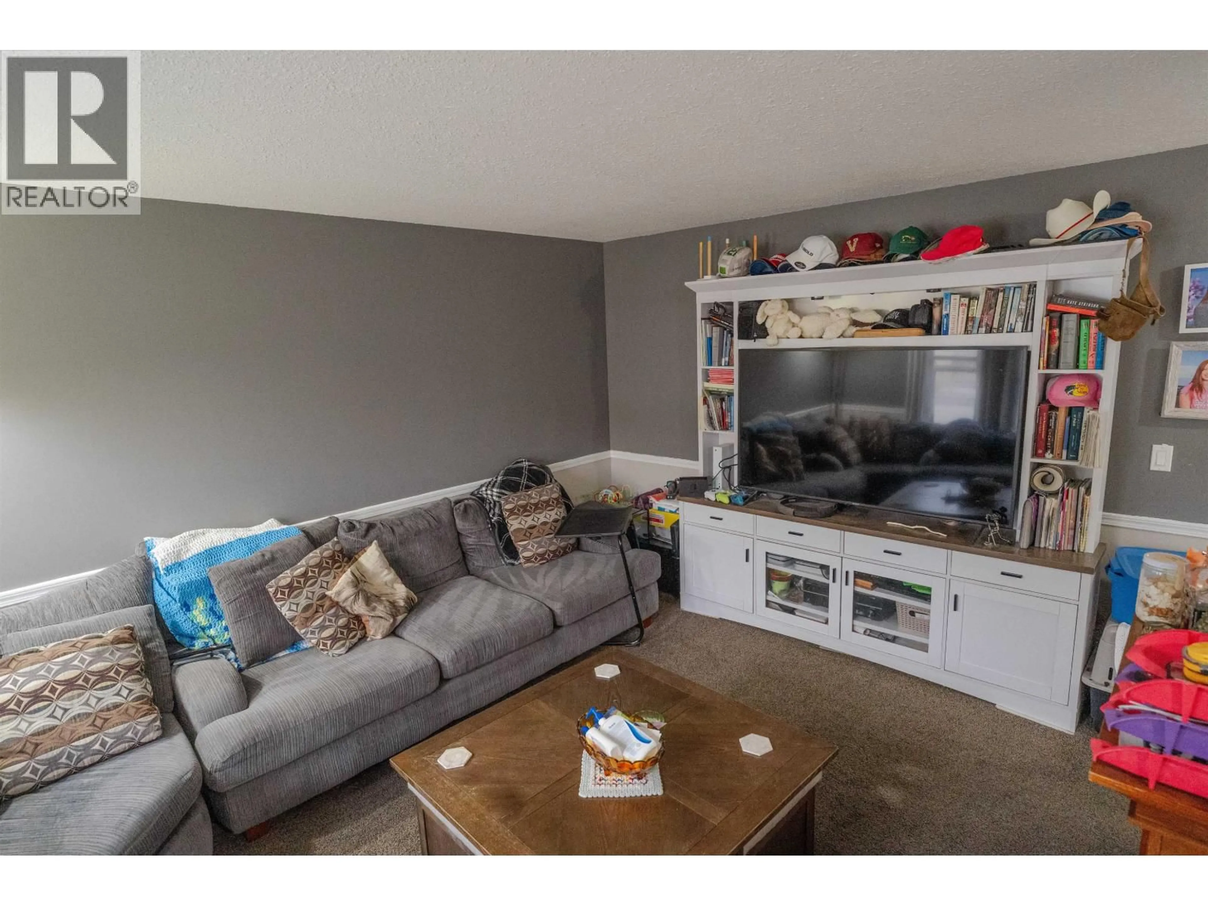 Living room with furniture, wood/laminate floor for 10219 102 AVENUE, Fort St. John British Columbia V1J2E4