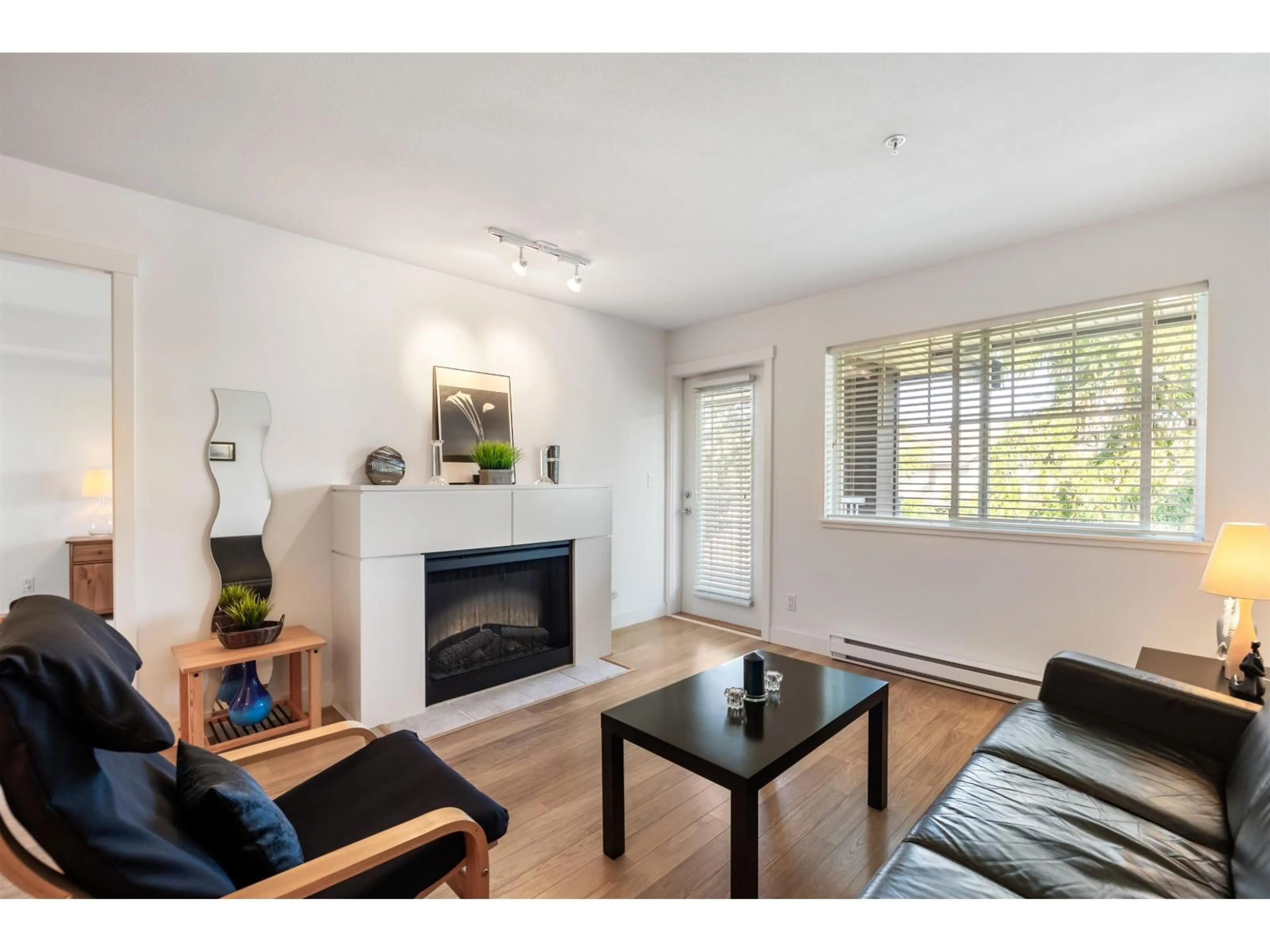 Living room with furniture, wood/laminate floor for 309 - 19320 65, Surrey British Columbia V4N0A3