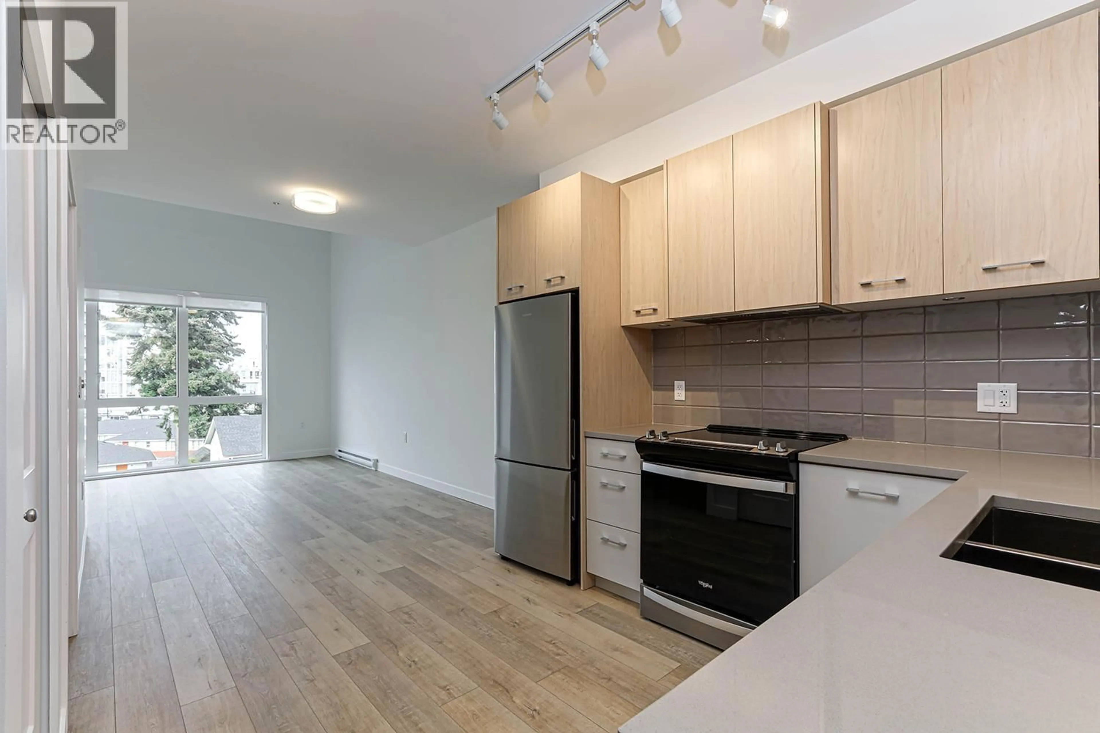 Open concept kitchen, wood/laminate floor for 411 - 4933 CLARENDON STREET, Vancouver British Columbia V5R3J3