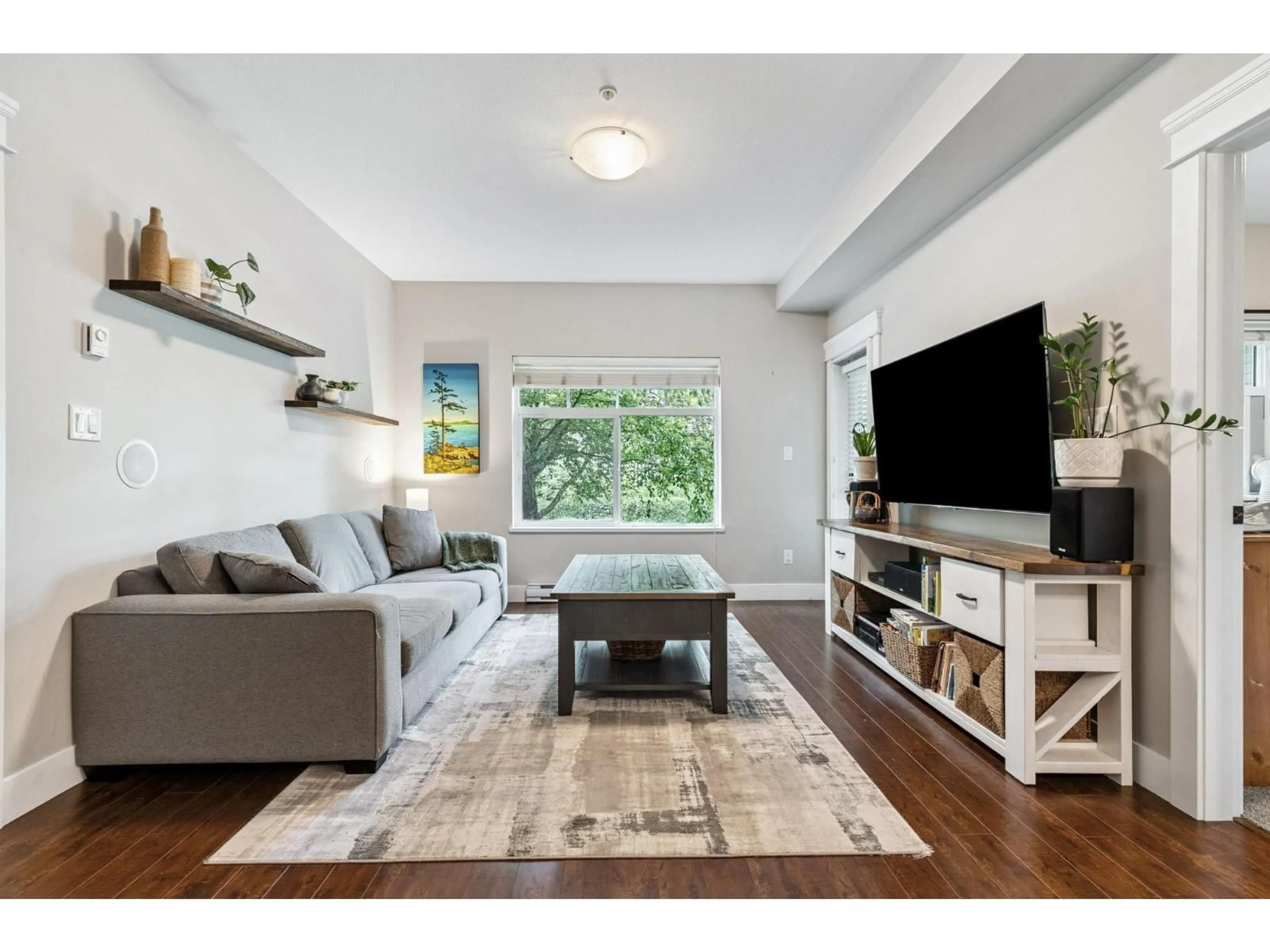 Living room with furniture, wood/laminate floor for 202 - 19530 65, Surrey British Columbia V4N6M1