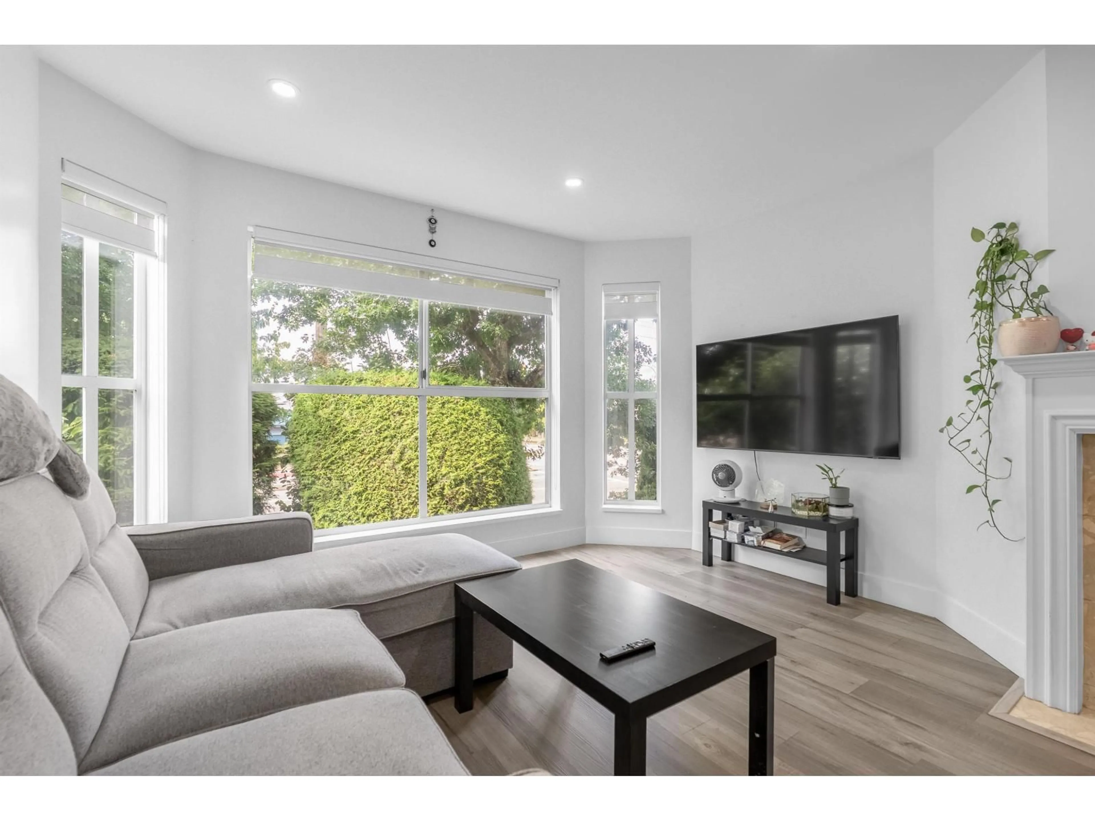 Living room with furniture, wood/laminate floor for 210 - 7171 121, Surrey British Columbia V3W1G9