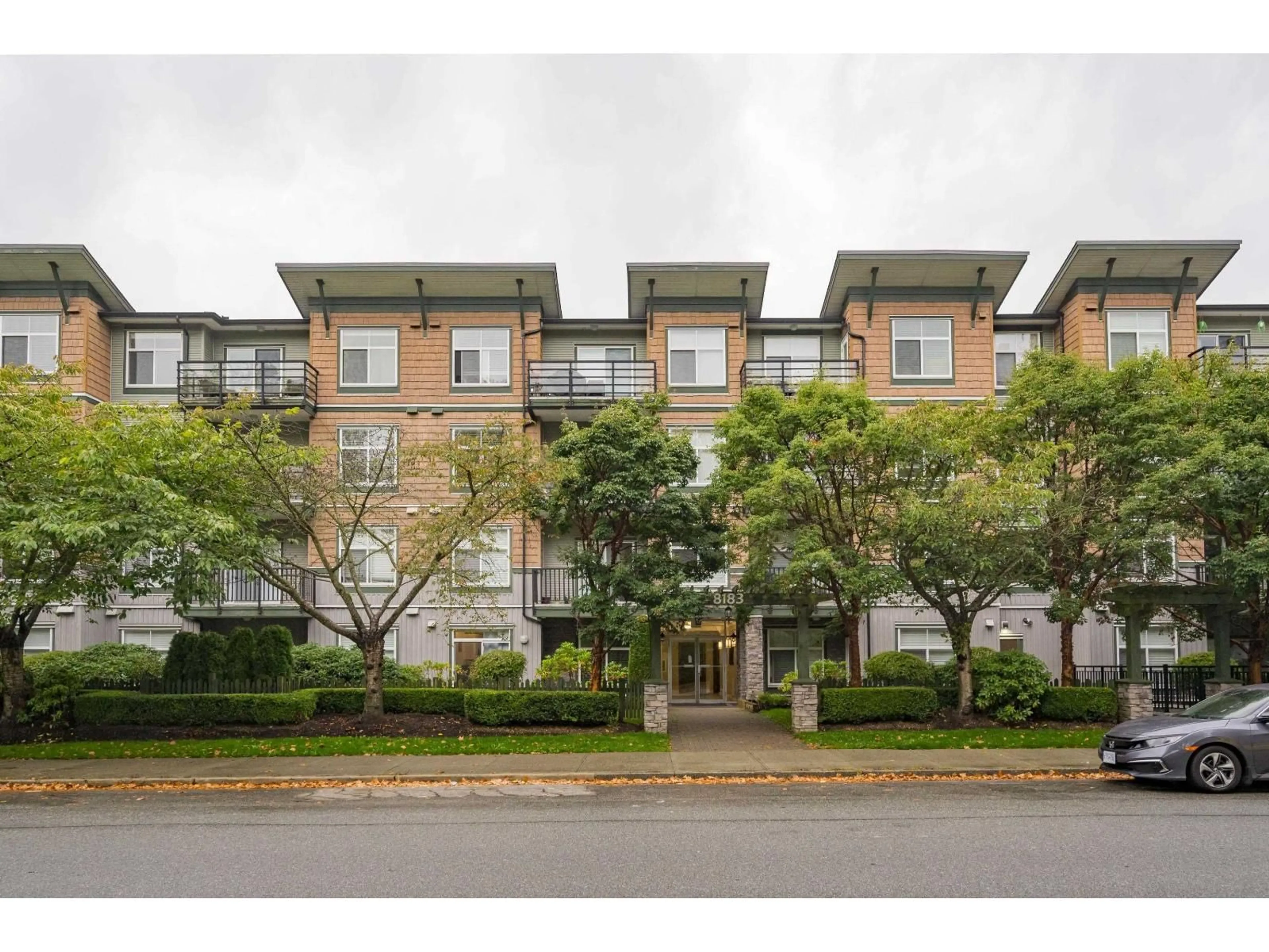A pic from outside/outdoor area/front of a property/back of a property/a pic from drone, street for 303 - 8183 121A, Surrey British Columbia V3W1S7