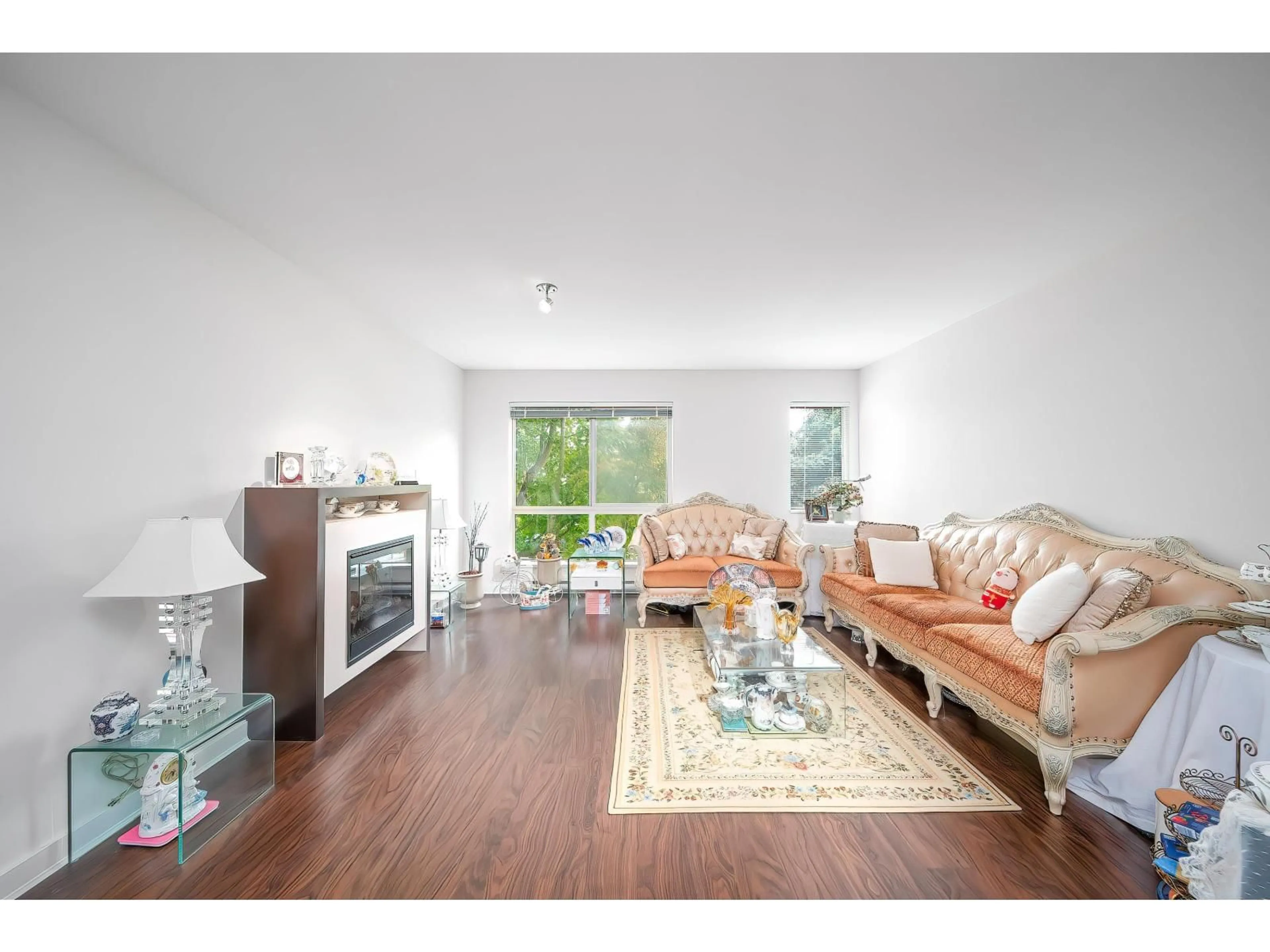 Living room with furniture, wood/laminate floor for 123 - 6671 121, Surrey British Columbia V3W1T9