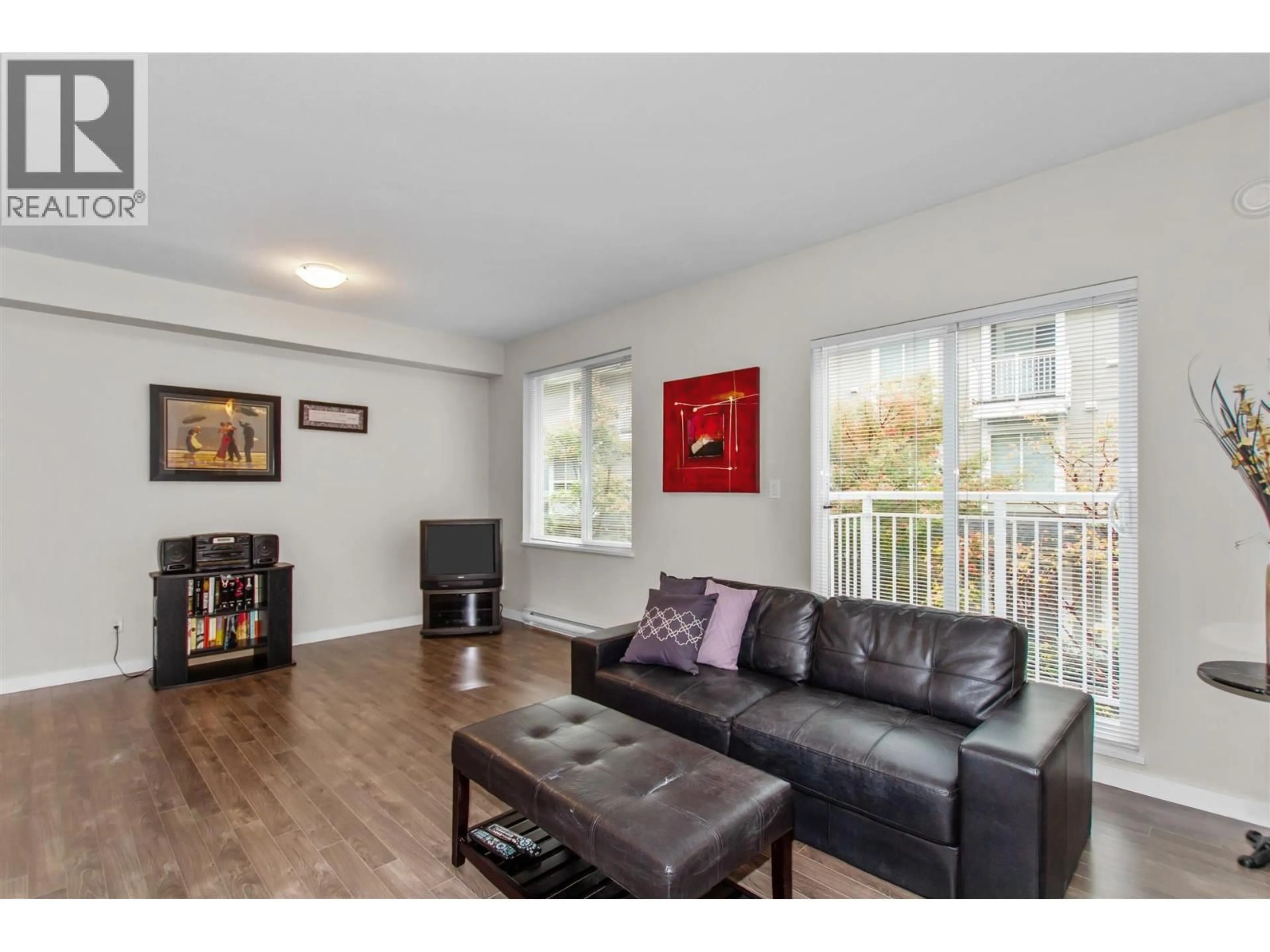 Living room with furniture, wood/laminate floor for 12 - 6965 HASTINGS STREET, Burnaby British Columbia V5B1S9