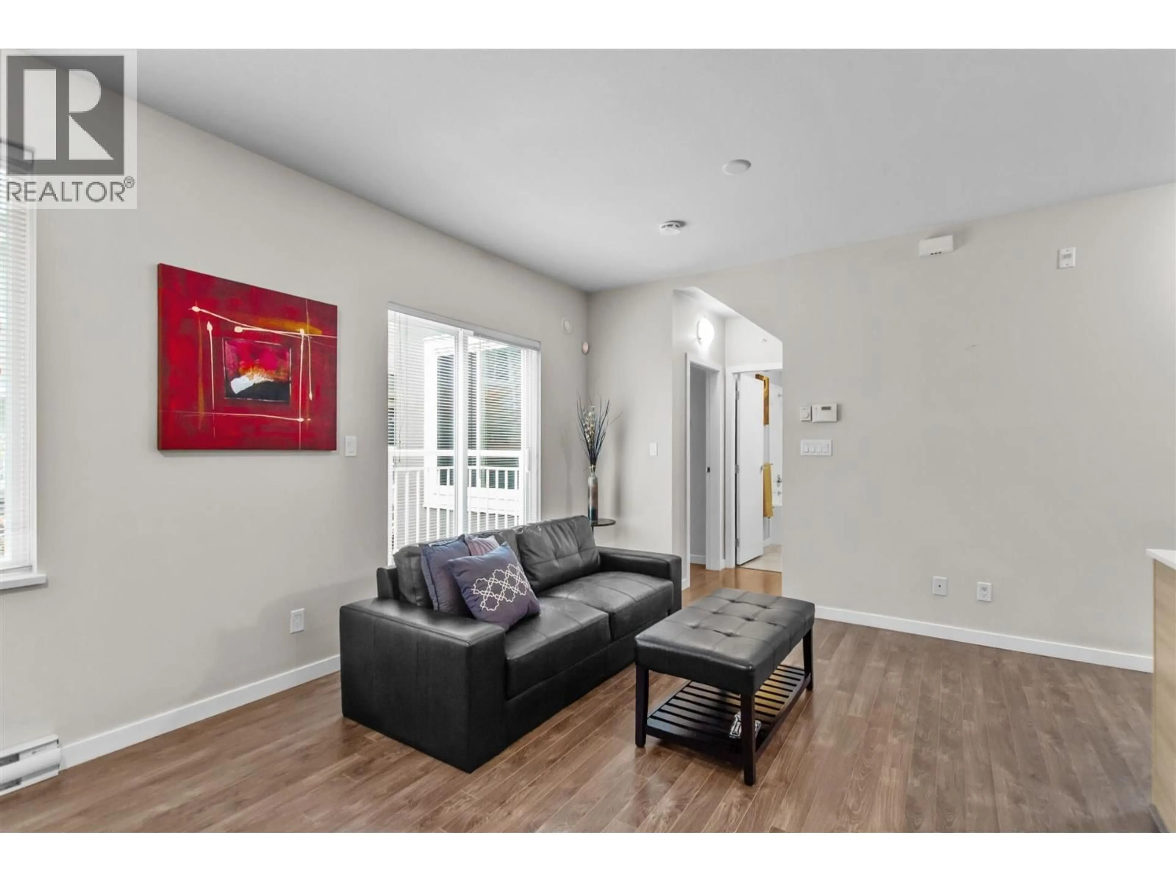 Living room with furniture, wood/laminate floor for 12 - 6965 HASTINGS STREET, Burnaby British Columbia V5B1S9