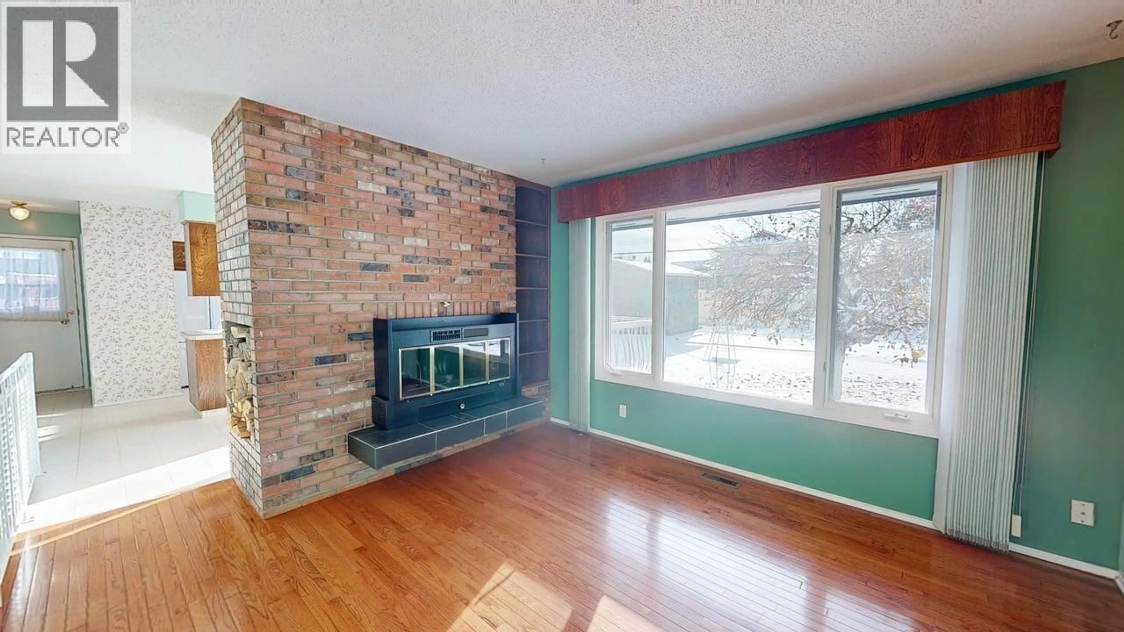 Living room with furniture, wood/laminate floor for 10415 109 AVENUE, Fort St. John British Columbia V1J2S2