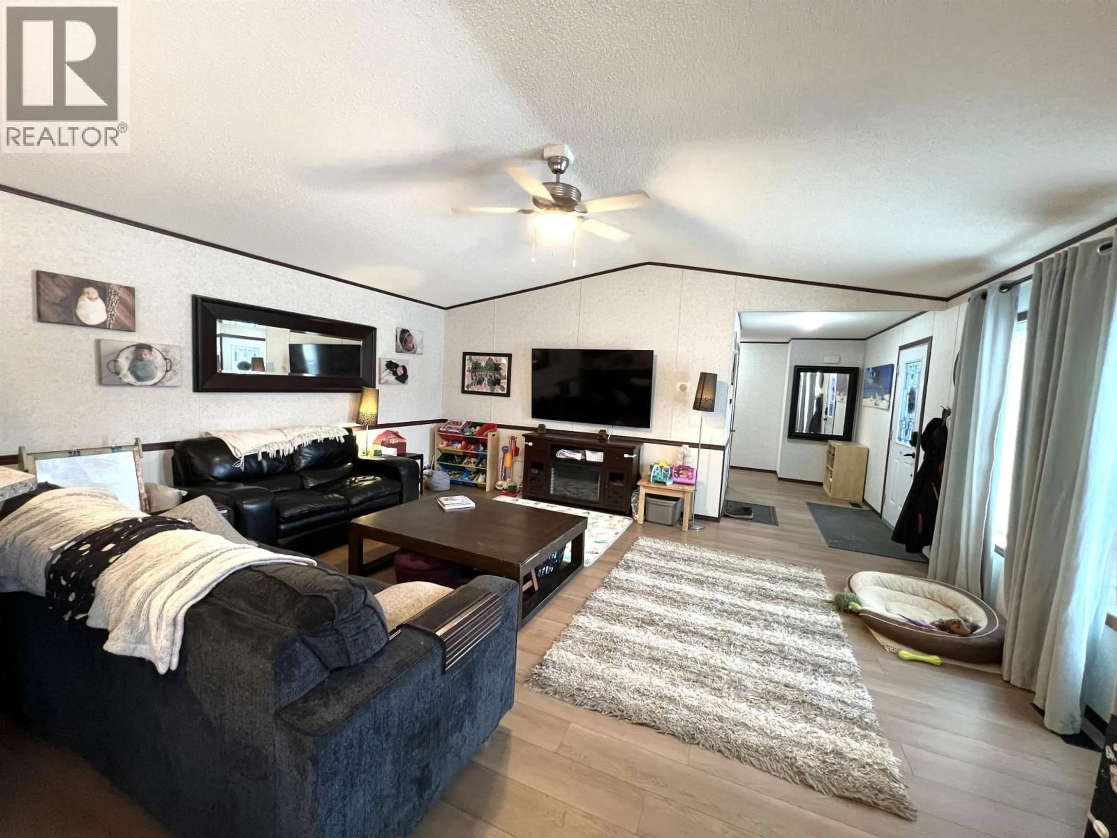 Living room with furniture, wood/laminate floor for 5506 PINE CRESCENT, Fort Nelson British Columbia V0C1R0