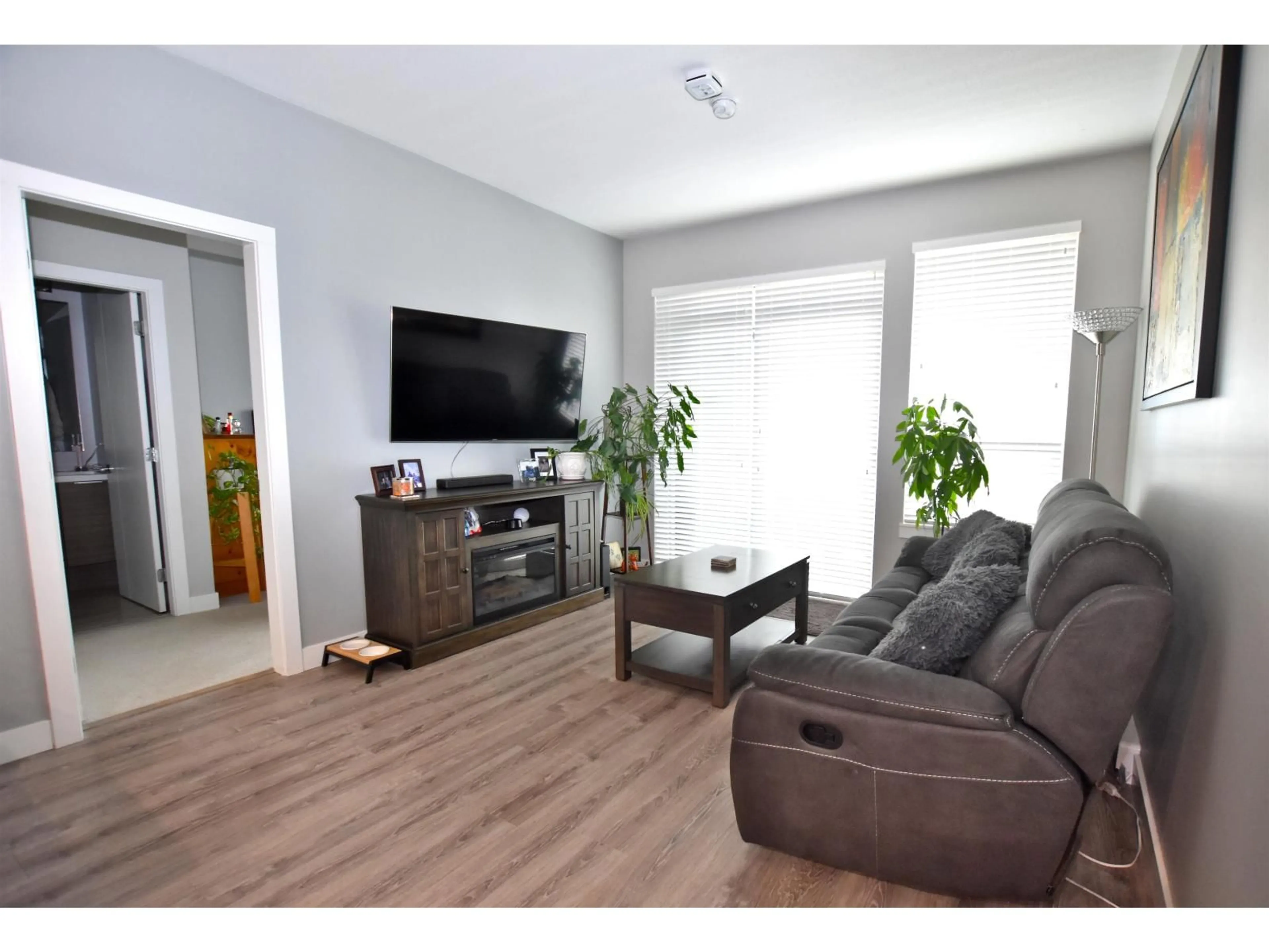 Living room with furniture, wood/laminate floor for 307 - 16380 64, Surrey British Columbia V3S6X6