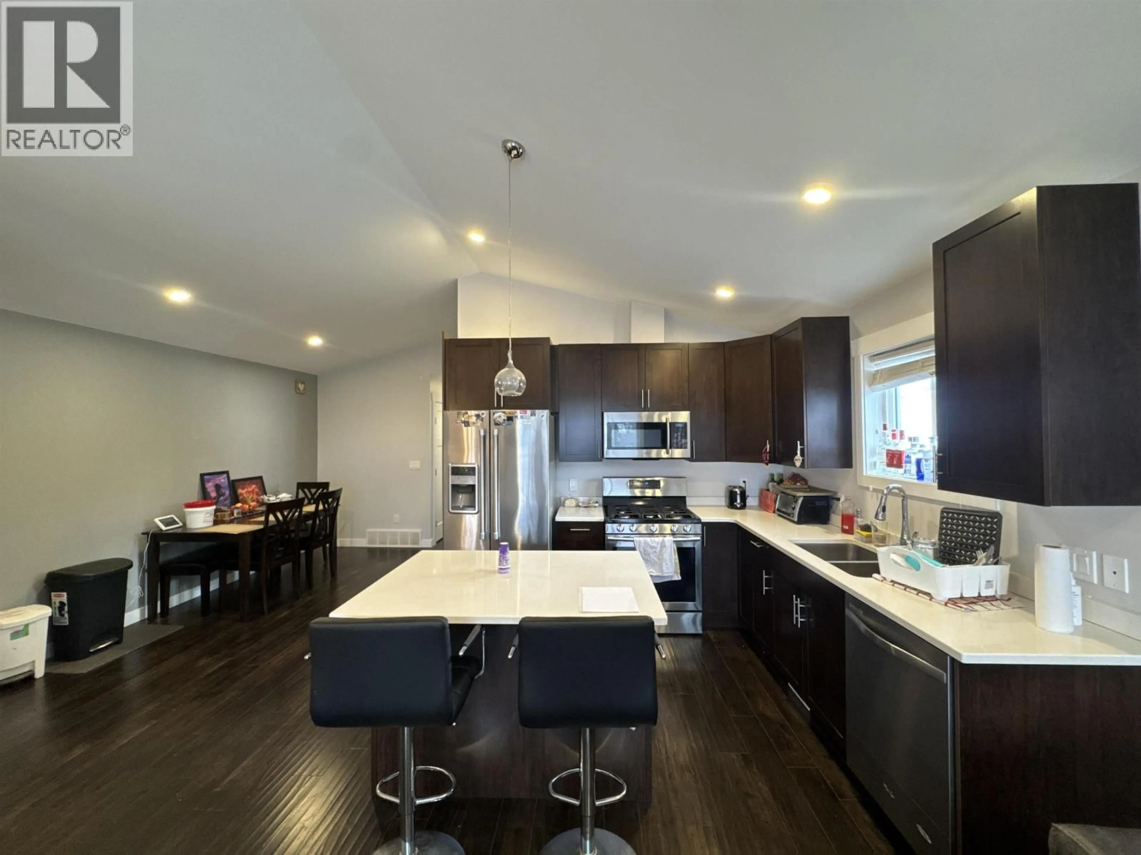 Open concept kitchen, wood/laminate floor for 8707 76 STREET, Fort St. John British Columbia V1J2Z5