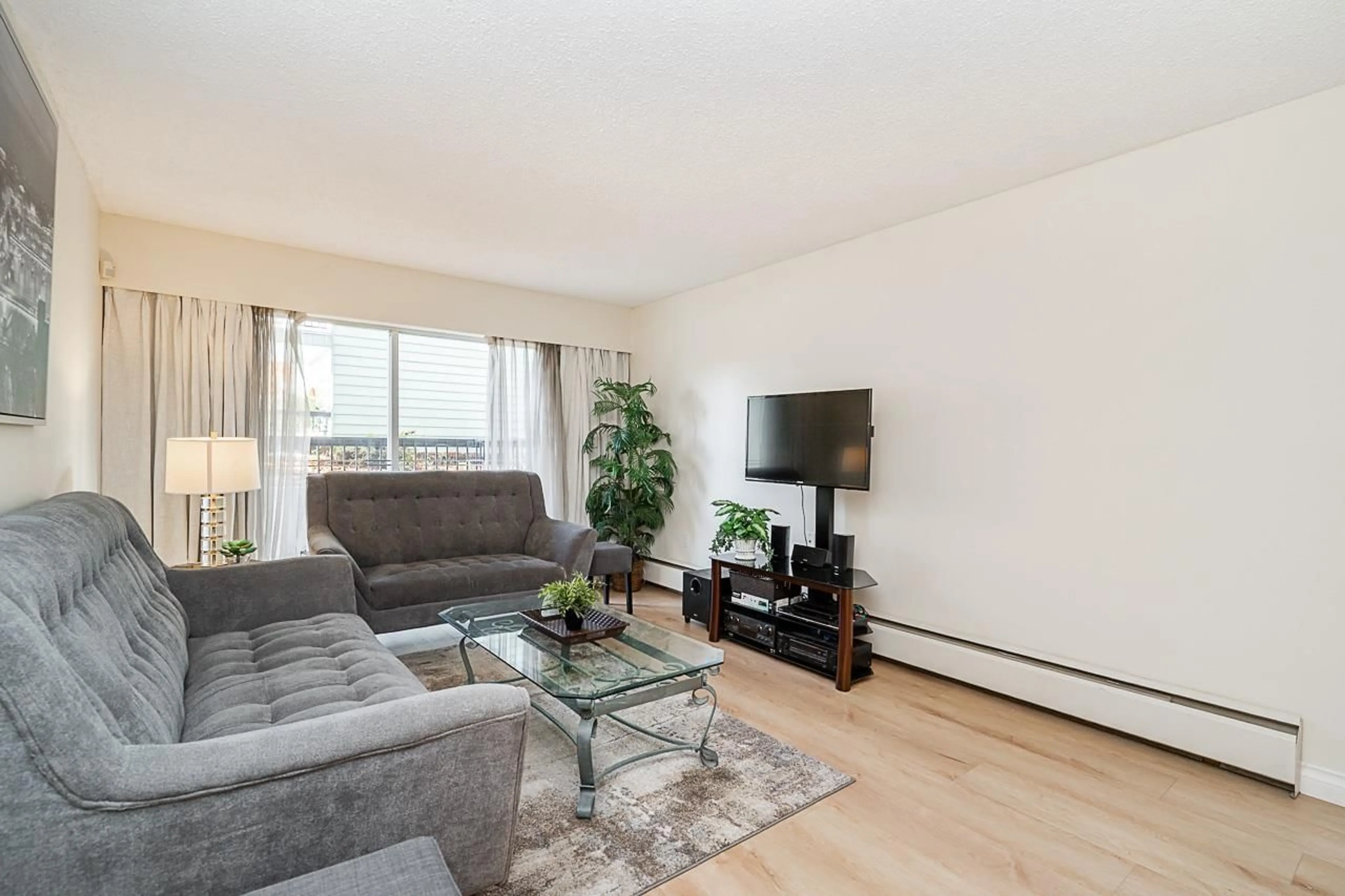 Living room with furniture, wood/laminate floor for 107A - 8635 120, Delta British Columbia V4C6R5