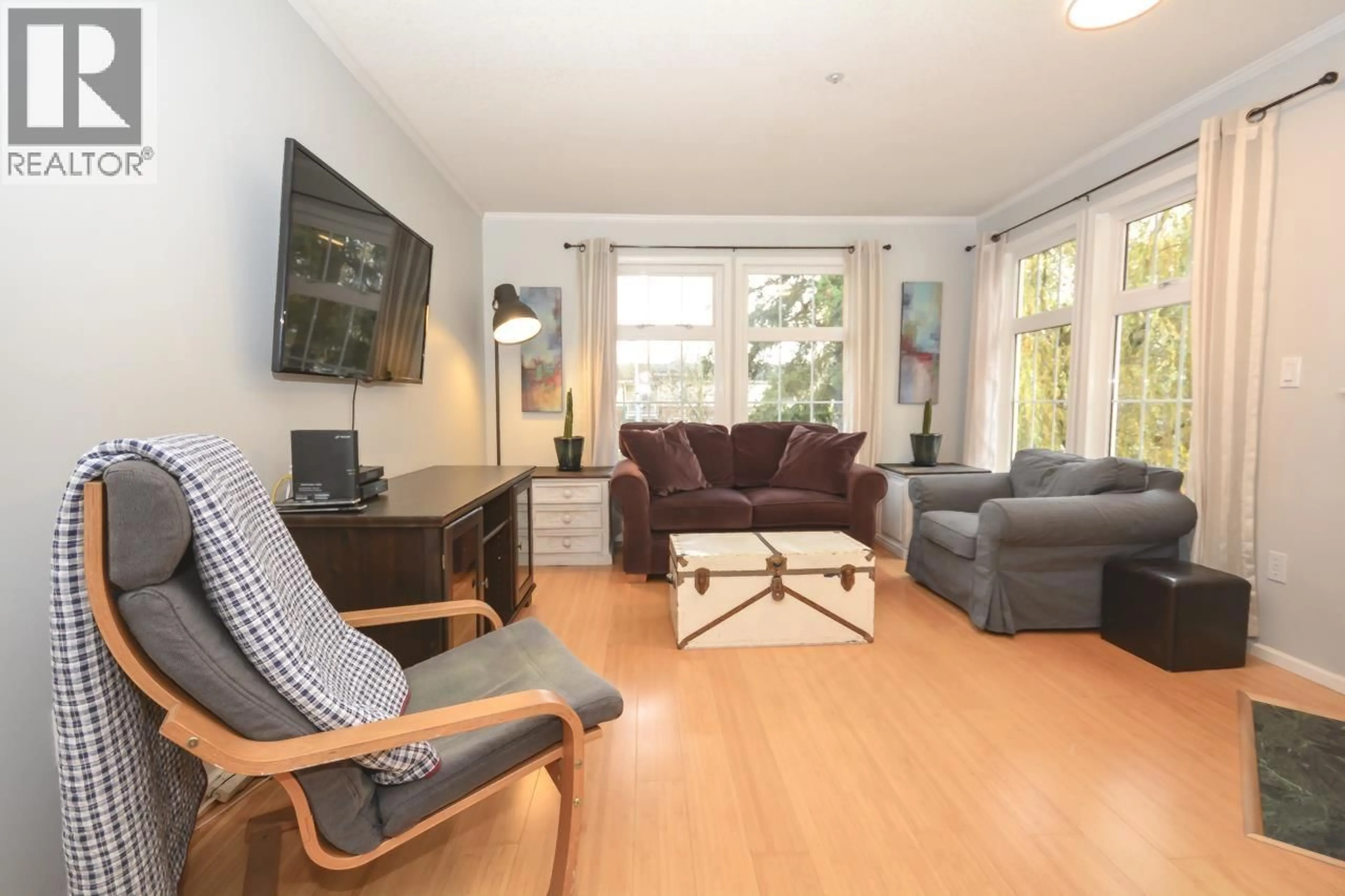 Living room with furniture, wood/laminate floor for 206 - 5556 14 AVENUE, Delta British Columbia V4M4E7