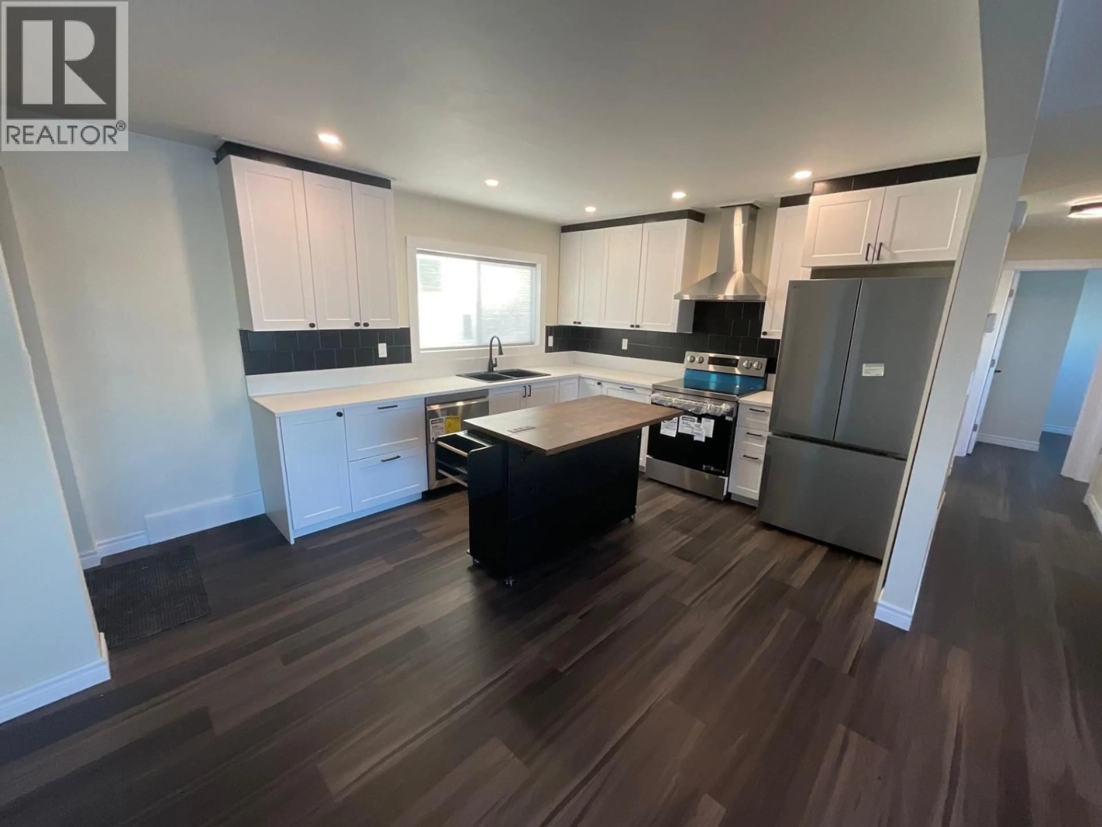 Open concept kitchen, wood/laminate floor for 8835 103 AVENUE, Fort St. John British Columbia V1J6P1
