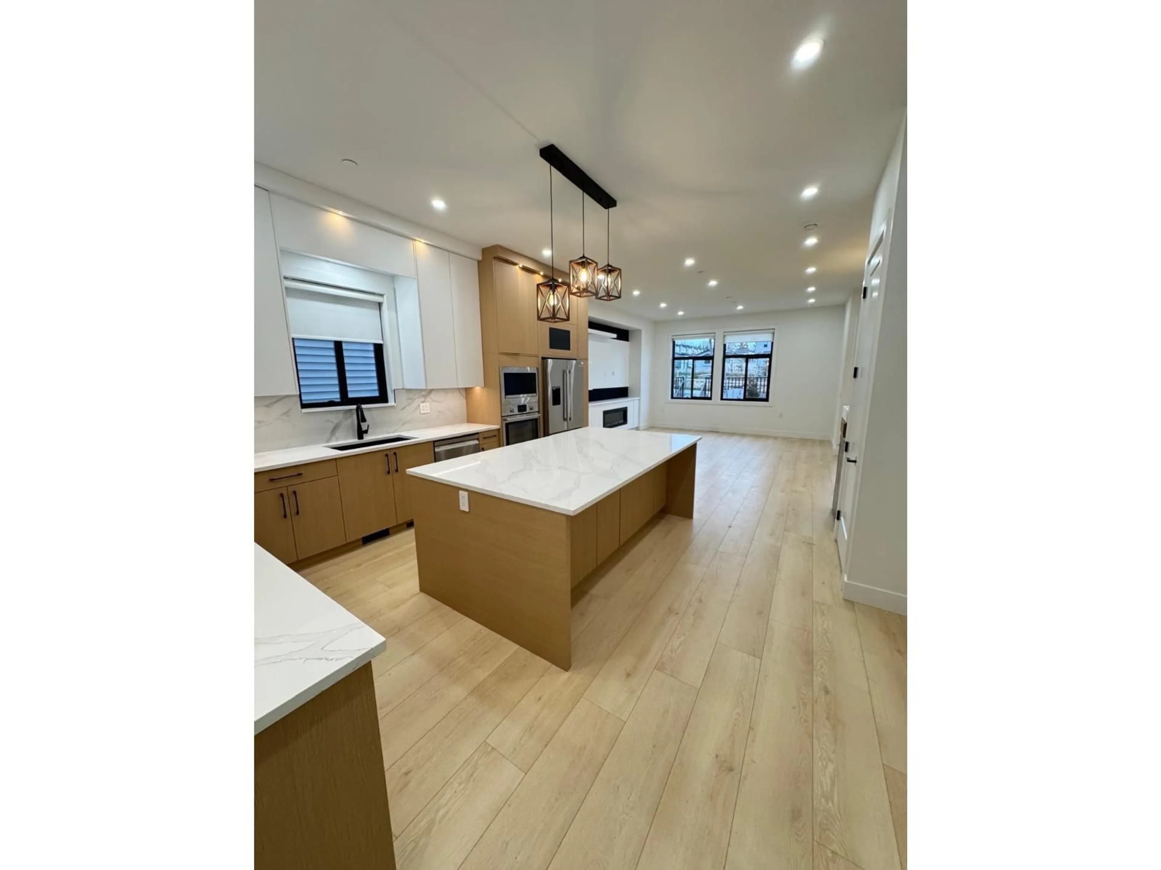 Open concept kitchen, wood/laminate floor for 7621 197 STREET, Langley British Columbia V3A7X8