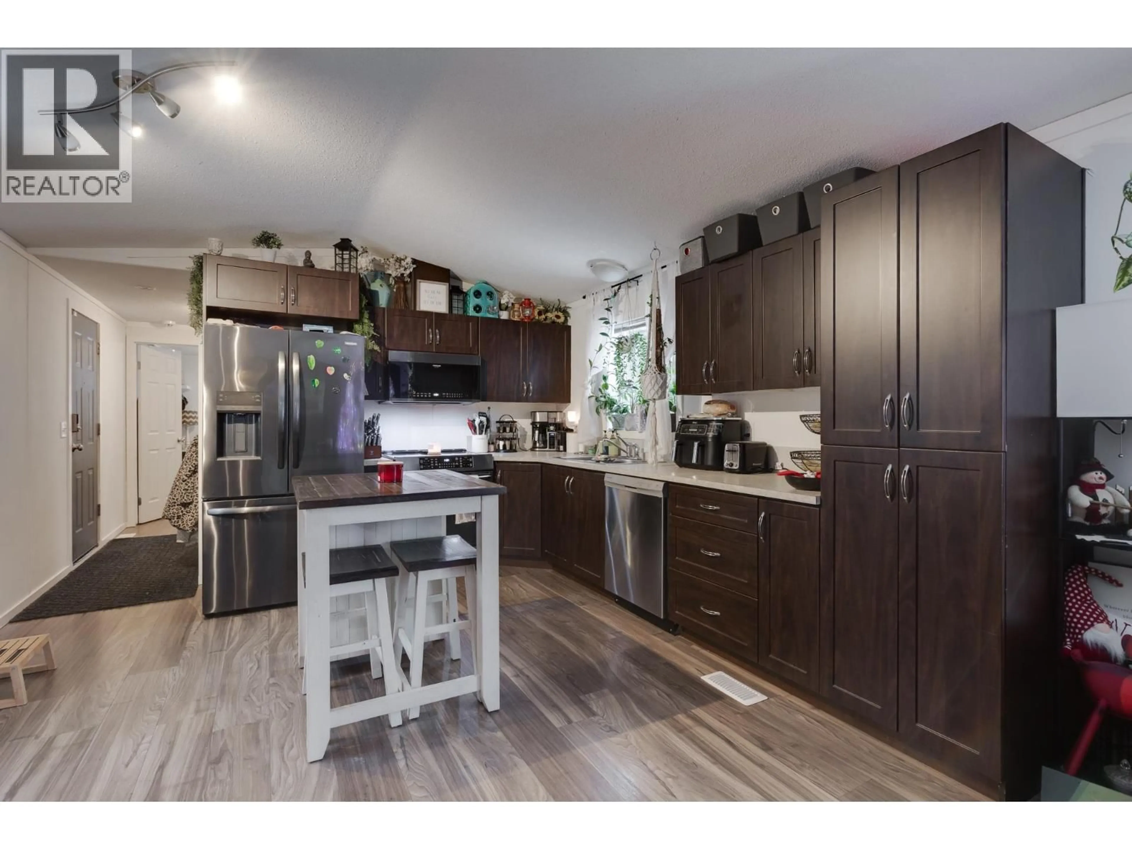 Open concept kitchen, wood/laminate floor for 7082 KENNEDY CRESCENT, Prince George British Columbia V2K2P8