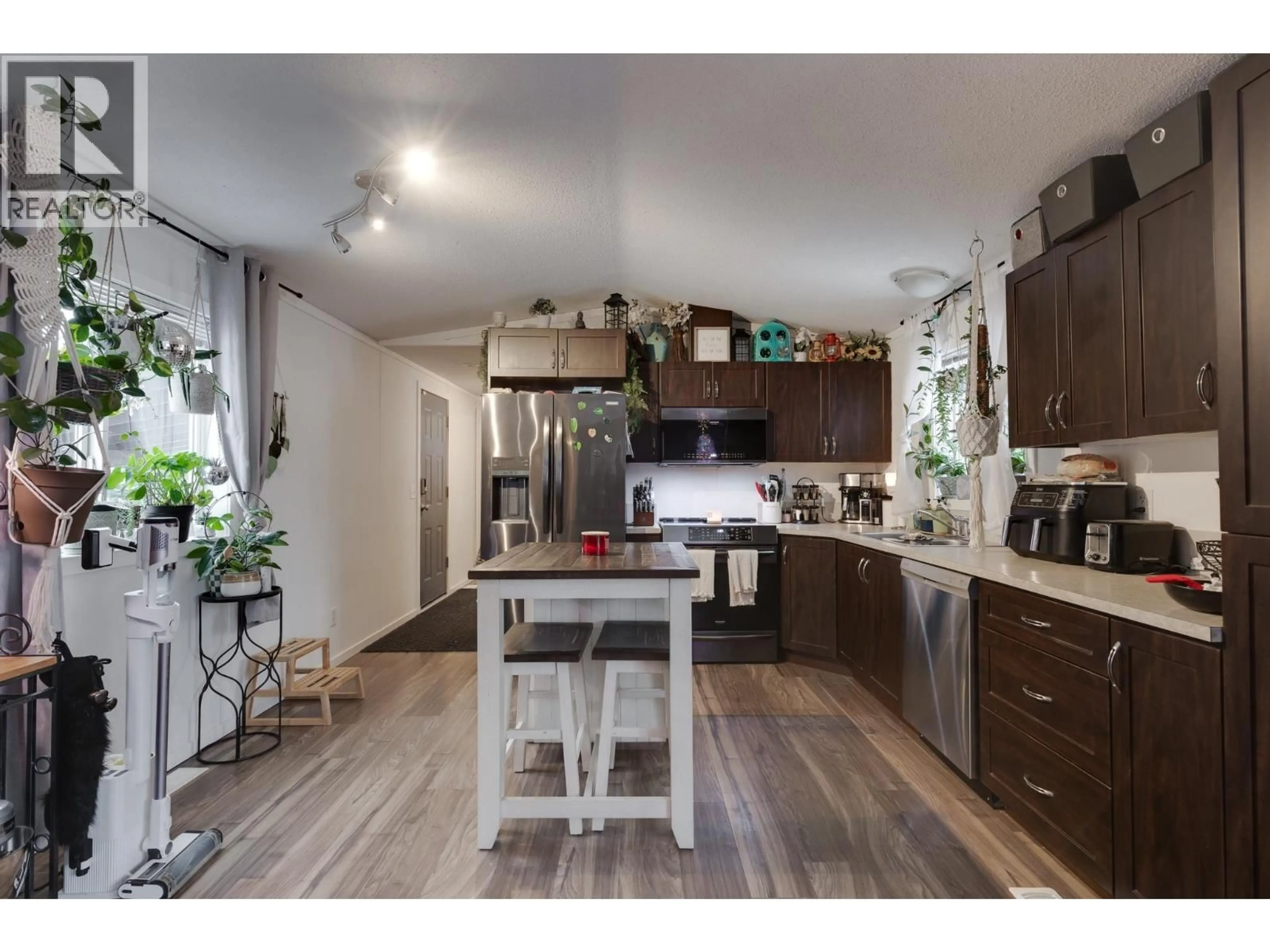 Open concept kitchen, wood/laminate floor for 7082 KENNEDY CRESCENT, Prince George British Columbia V2K2P8