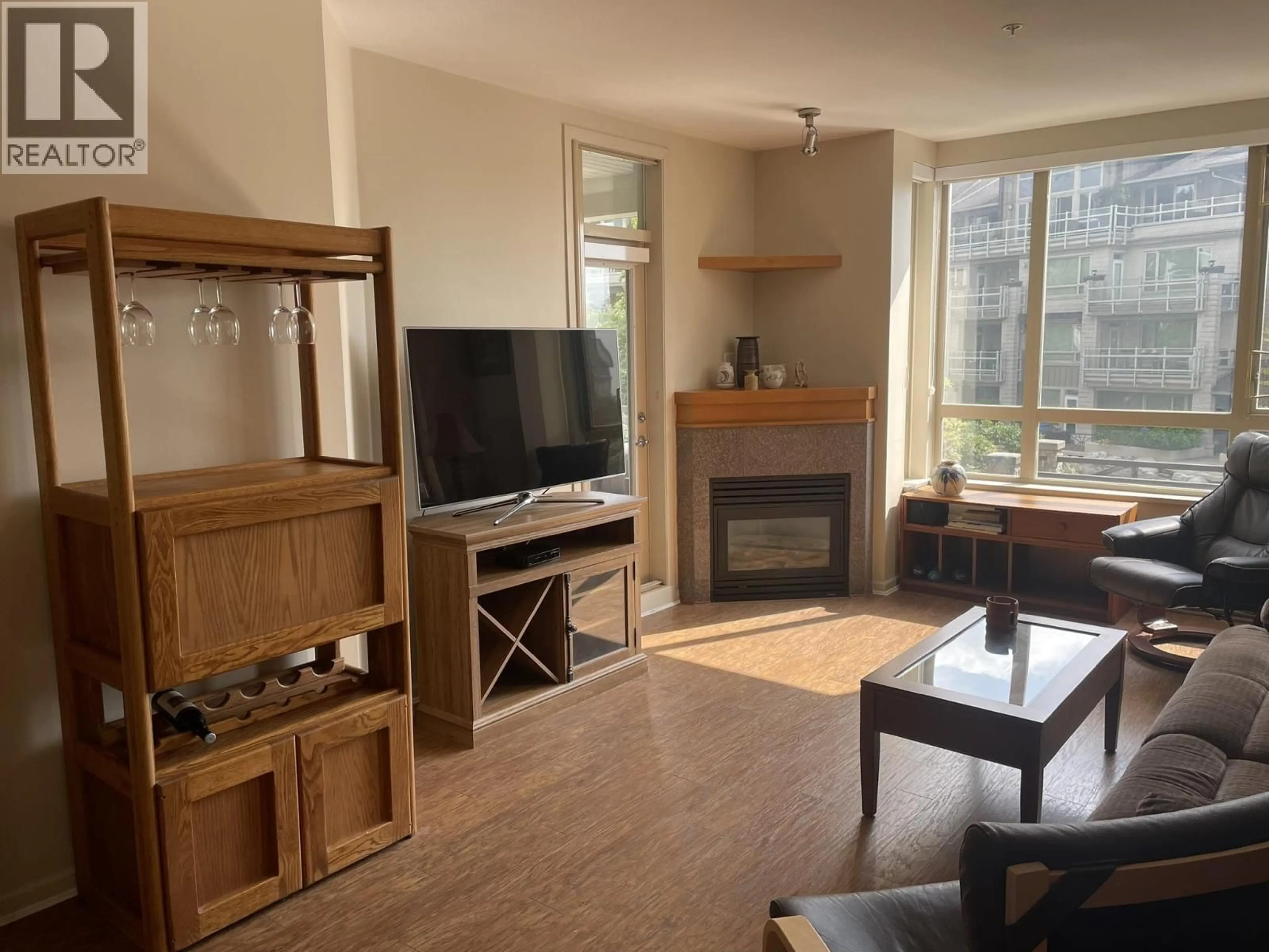 Living room with furniture, wood/laminate floor for 207 - 580 RAVEN WOODS DRIVE, North Vancouver British Columbia V7G2T2