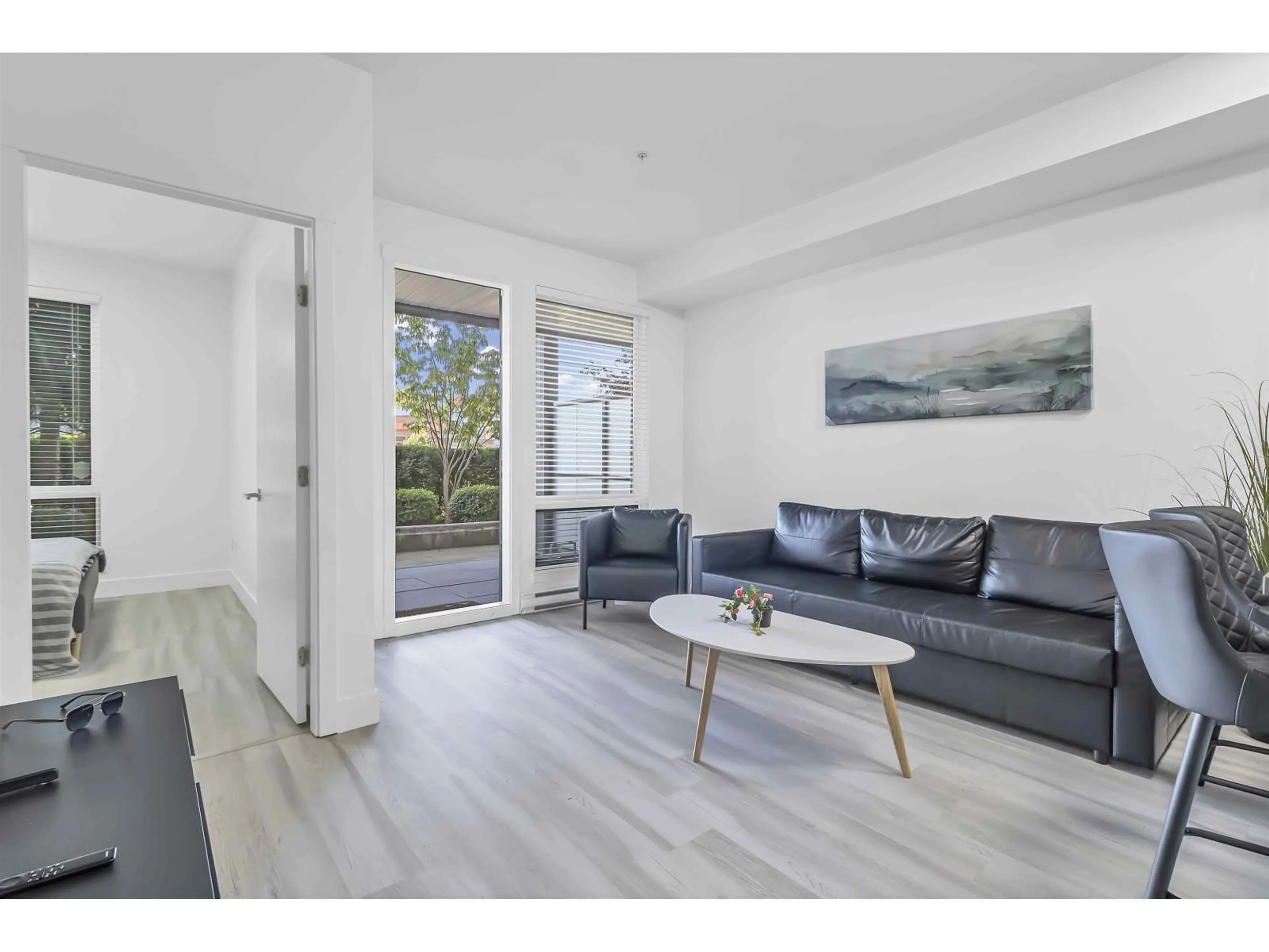 Living room with furniture, wood/laminate floor for 101 - 15628 104 AVENUE, Surrey British Columbia V4N2J3