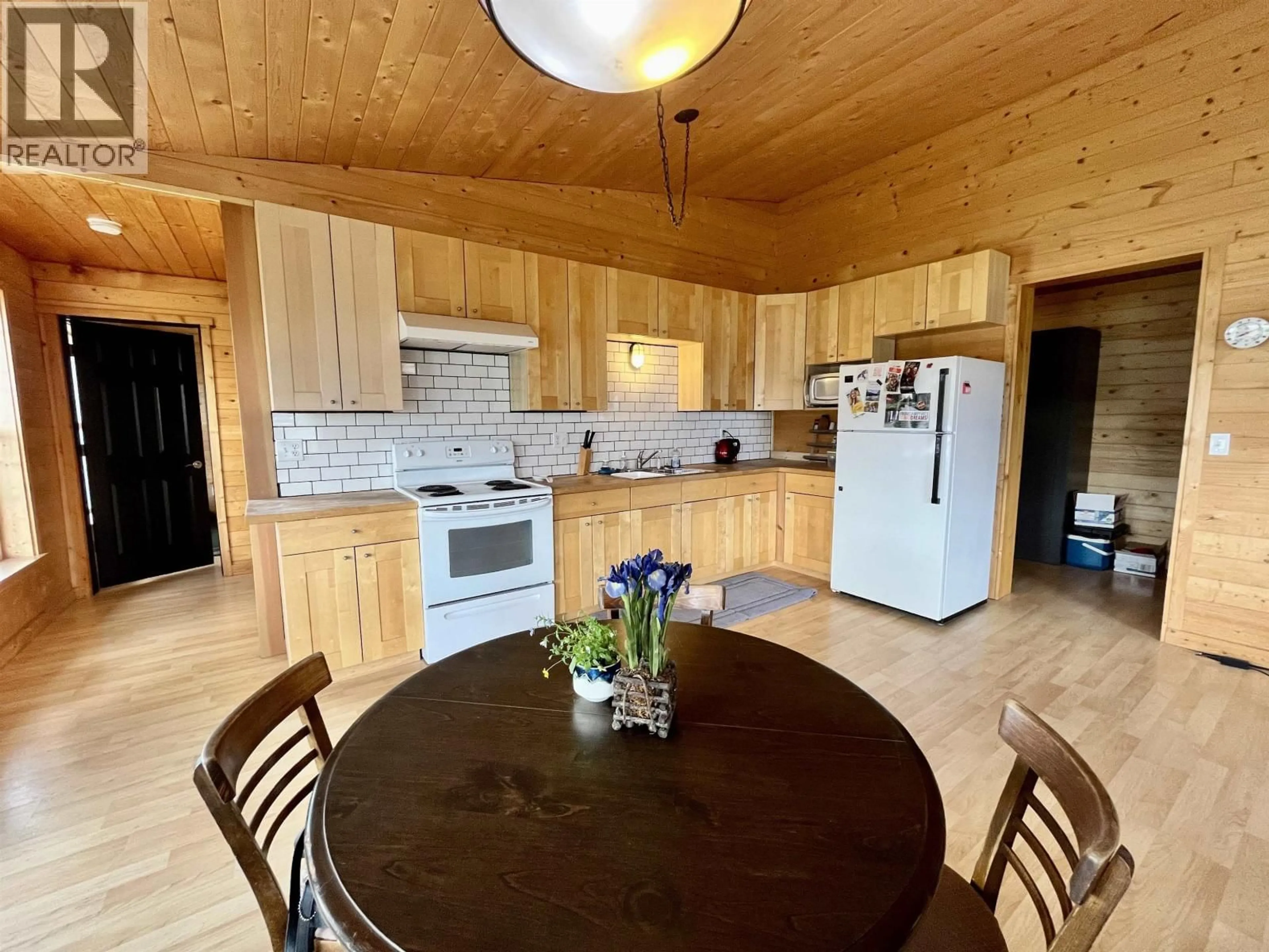 Open concept kitchen, wood/laminate floor for 5574 LAKESIDE COURT, 100 Mile House British Columbia V0K2E1