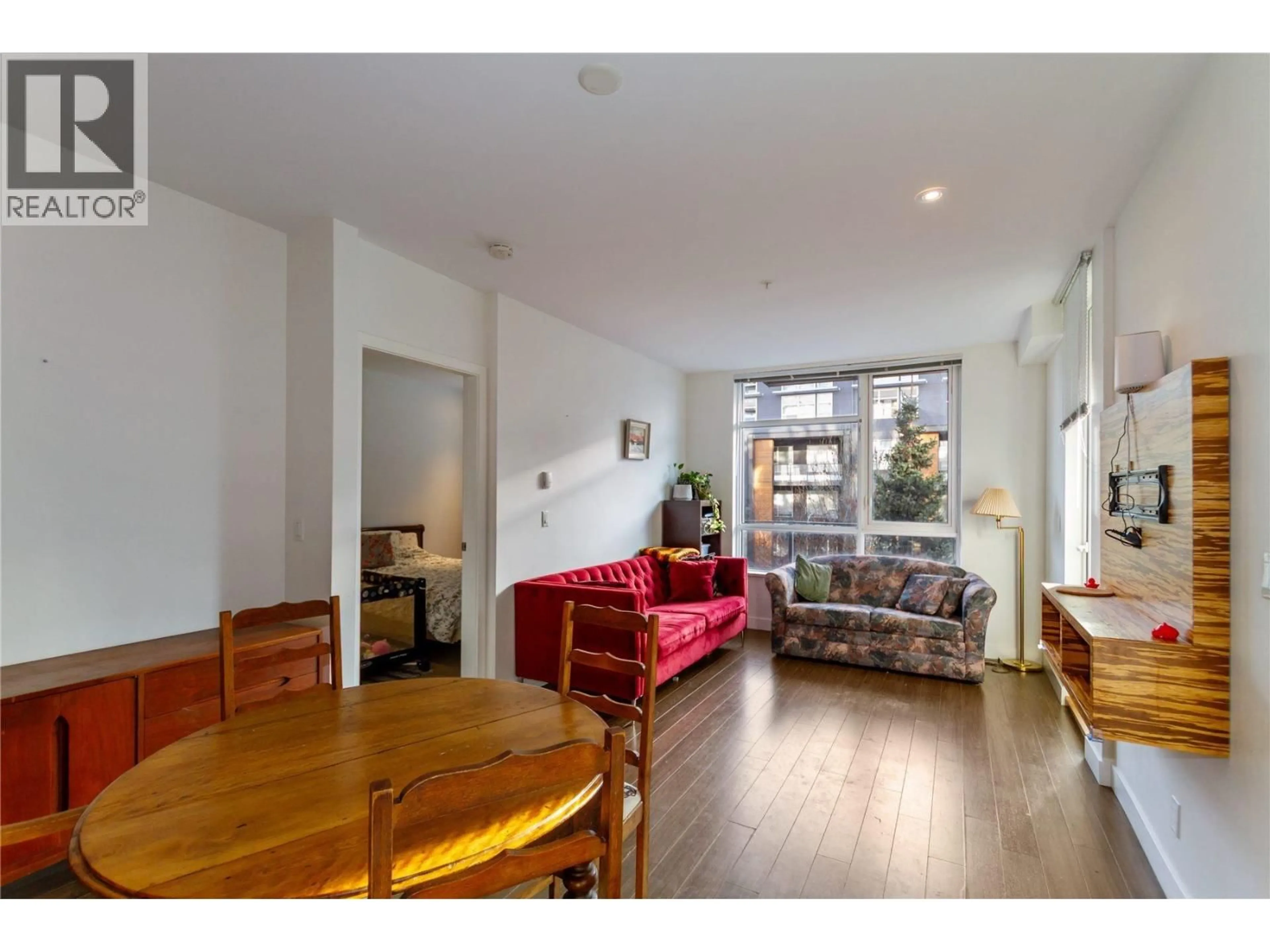 Living room with furniture, wood/laminate floor for 101 - 9150 UNIVERSITY HIGH STREET, Burnaby British Columbia V5A0C5