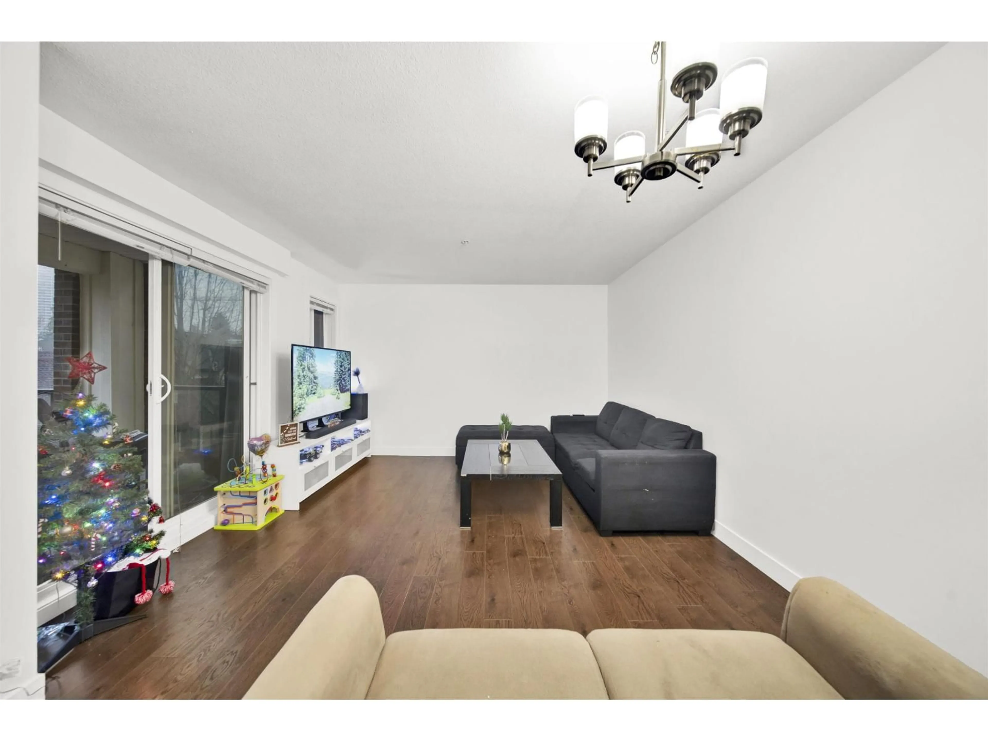 Living room with furniture, wood/laminate floor for 305 - 13883 LAUREL DRIVE, Surrey British Columbia V2R0W1