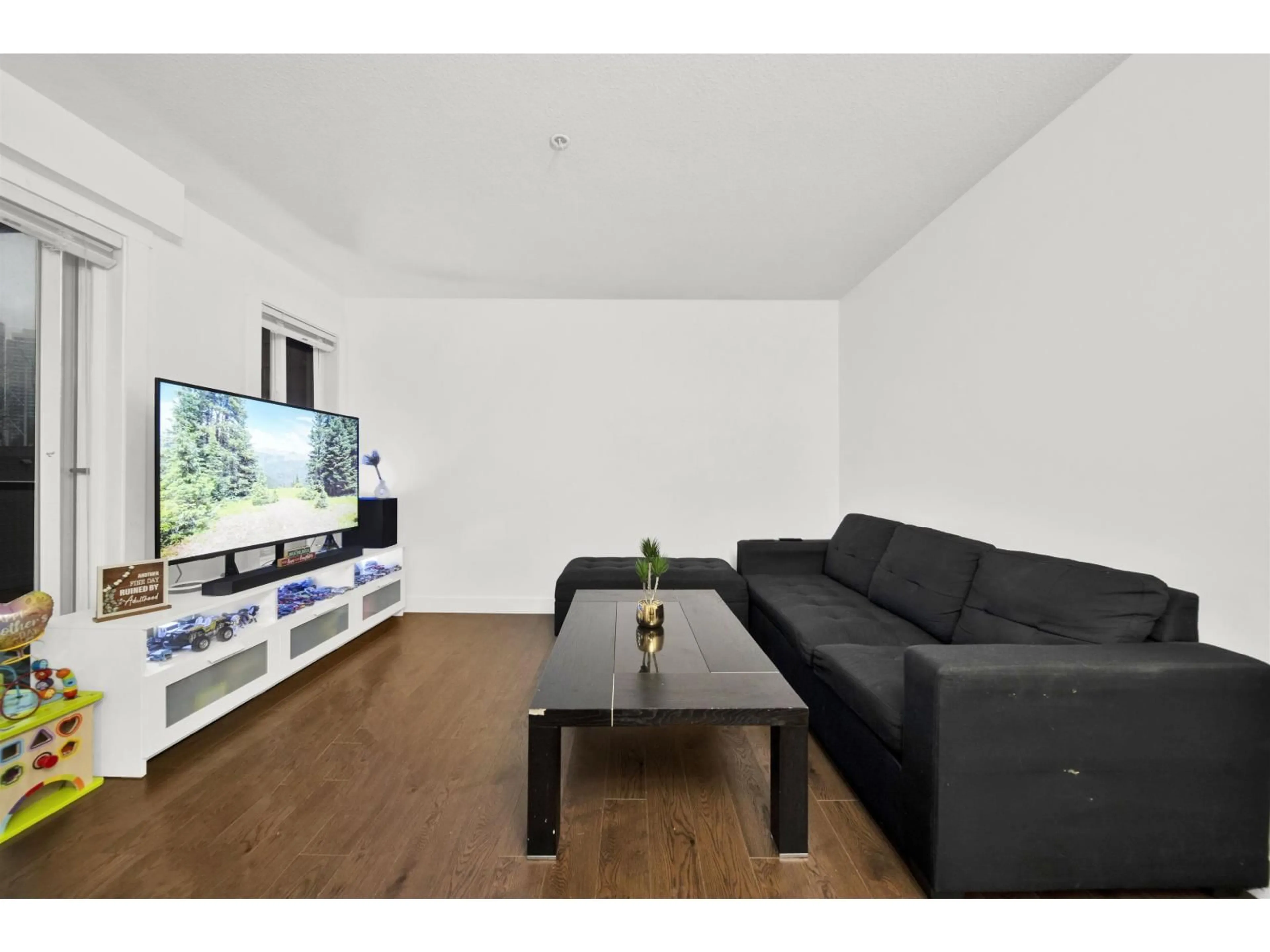 Living room with furniture, wood/laminate floor for 305 - 13883 LAUREL DRIVE, Surrey British Columbia V2R0W1