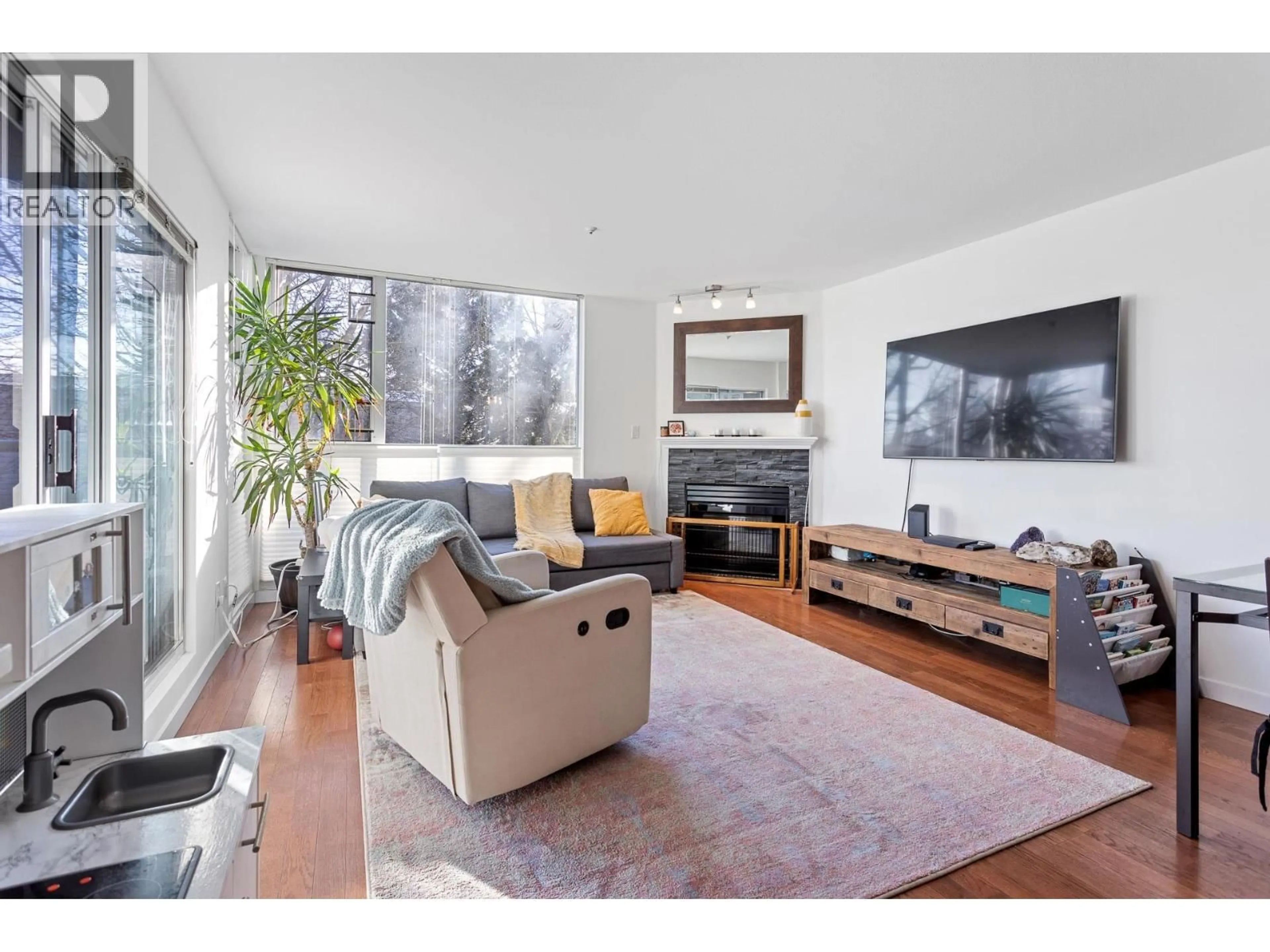 Living room with furniture, wood/laminate floor for 212 - 8460 JELLICOE STREET, Vancouver British Columbia V5S4S8
