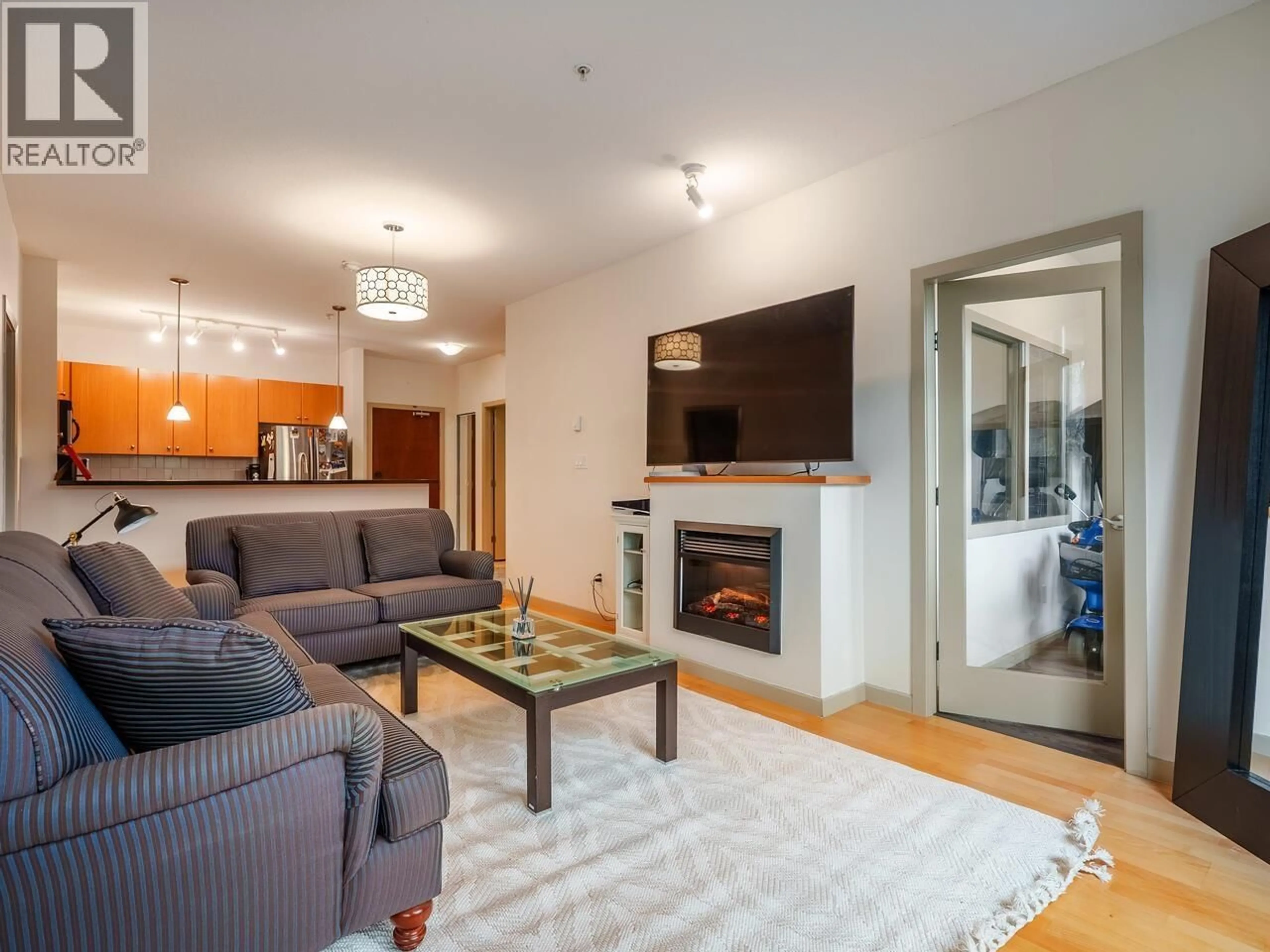 Living room with furniture, wood/laminate floor for 105 - 100 CAPILANO ROAD, Port Moody British Columbia V3H5M9