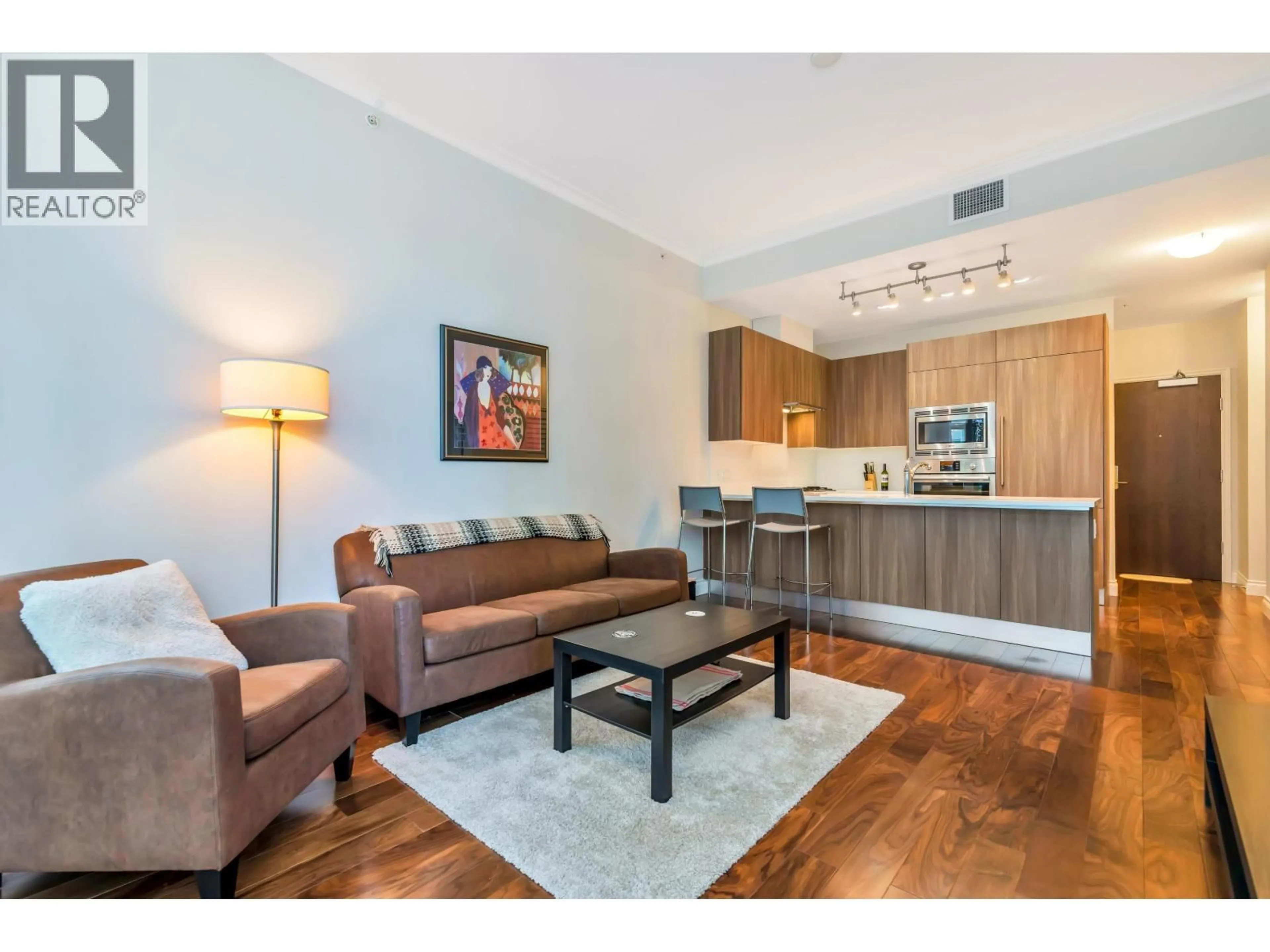 Living room with furniture, wood/laminate floor for 103 - 185 VICTORY SHIP WAY, North Vancouver British Columbia V7L0G2