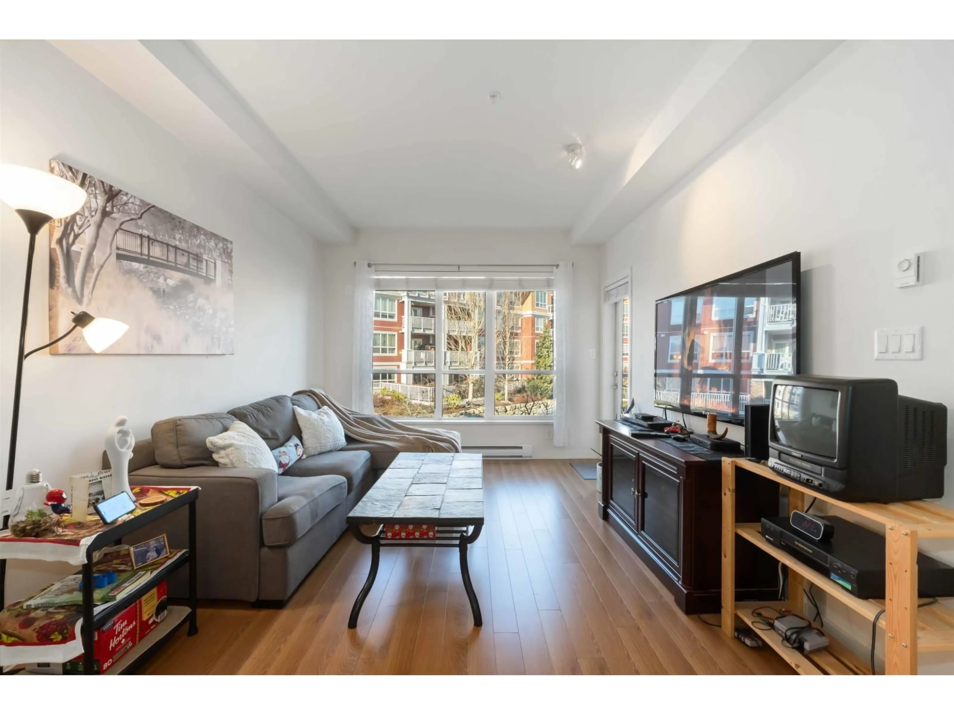 Living room with furniture, wood/laminate floor for 414 - 6440 194 STREET, Surrey British Columbia V4N6J7