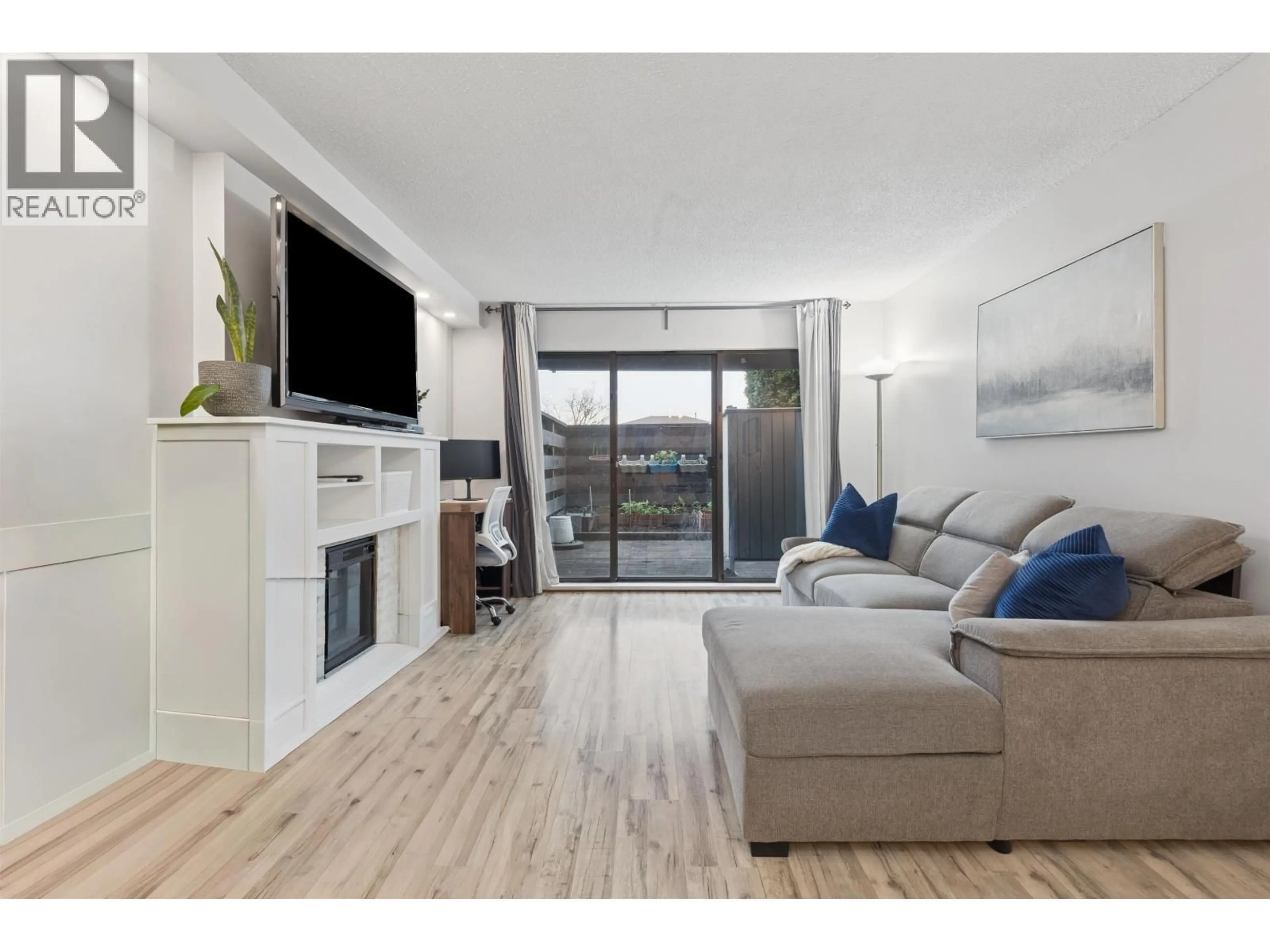 Living room with furniture, wood/laminate floor for 102 - 4111 FRANCIS ROAD, Richmond British Columbia V7C1J8