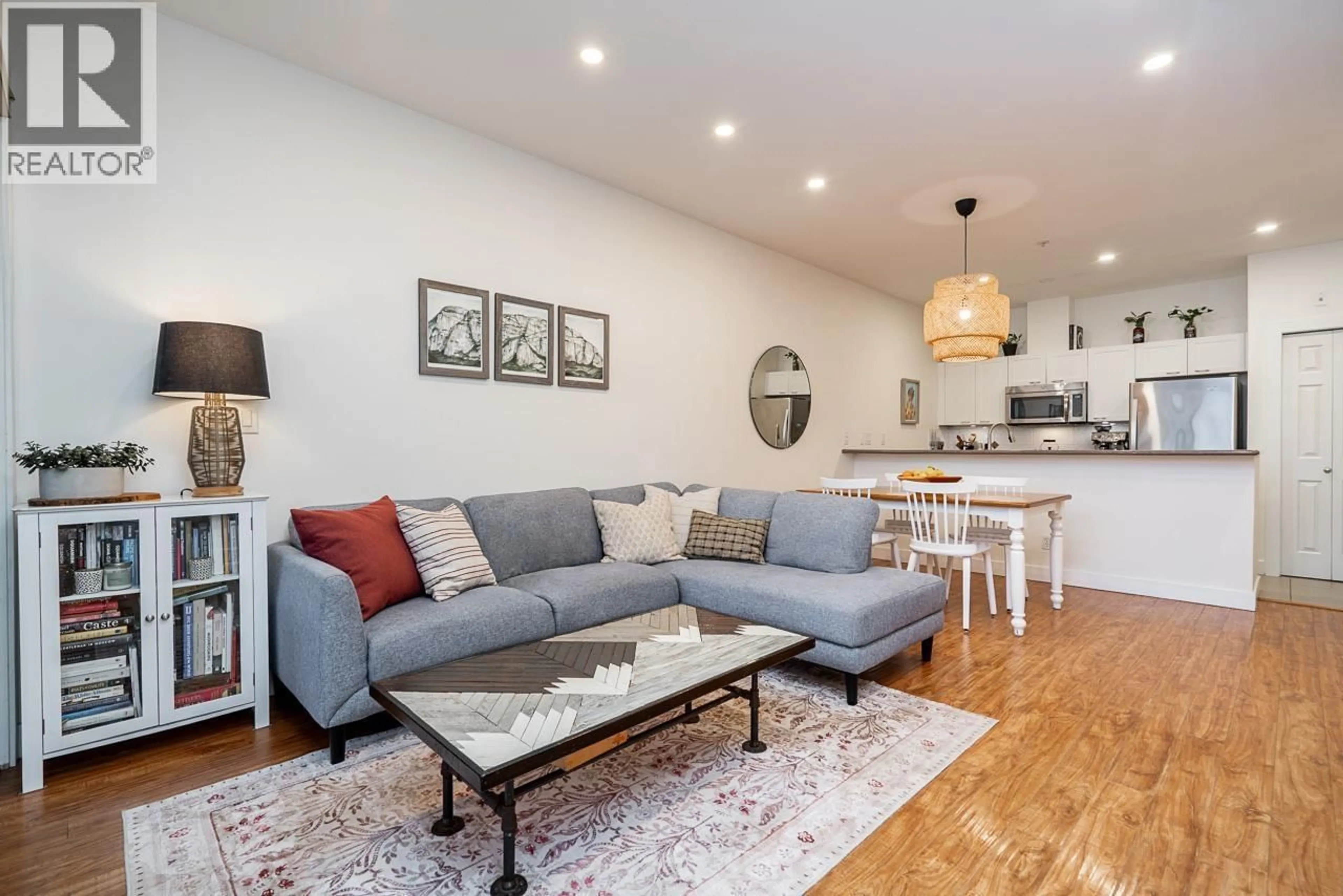 Living room with furniture, wood/laminate floor for 202 - 131 3RD STREET, North Vancouver British Columbia V7M1E7