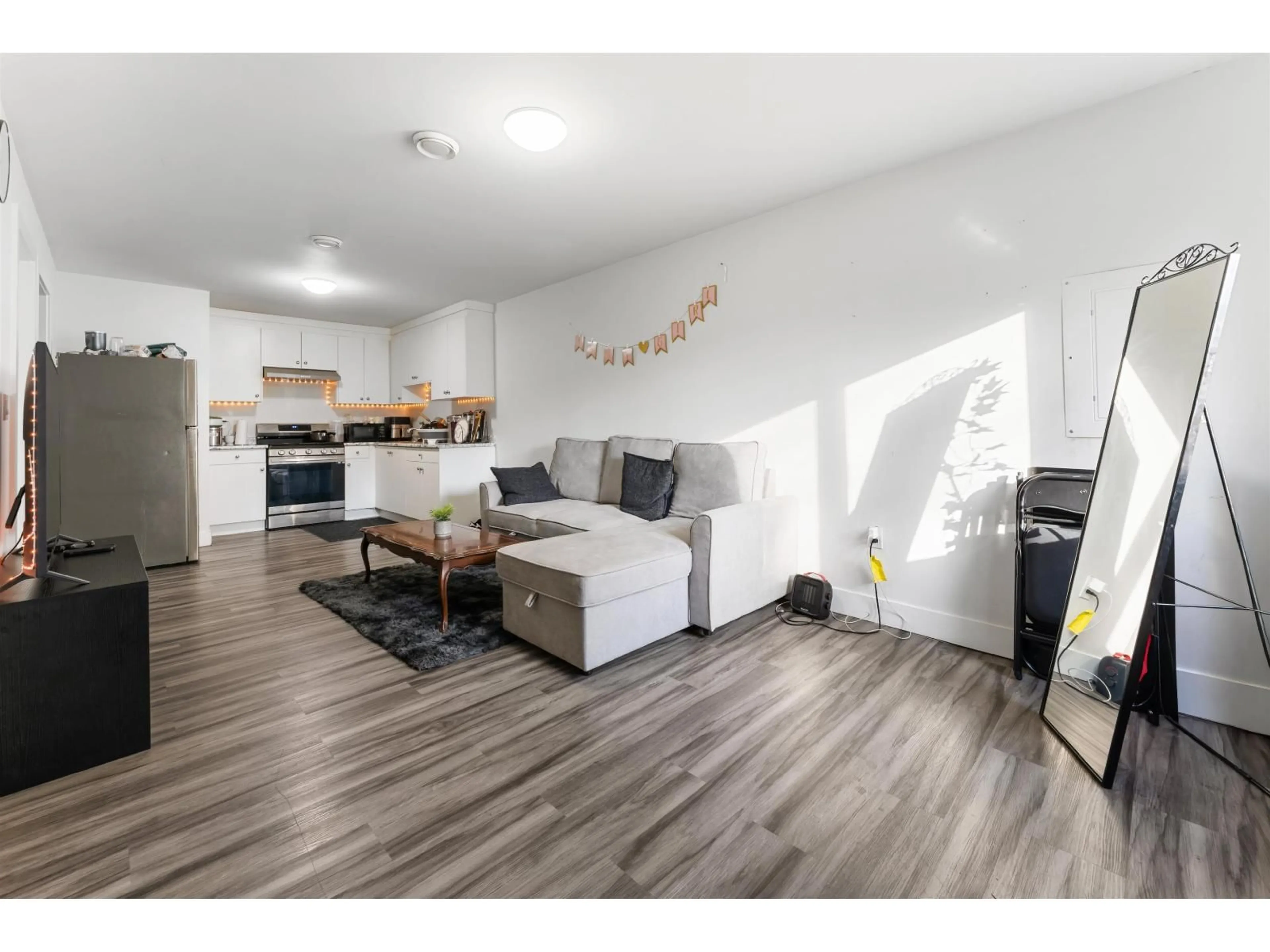 Living room with furniture, wood/laminate floor for 7309 123 STREET, Surrey British Columbia V3W9J2