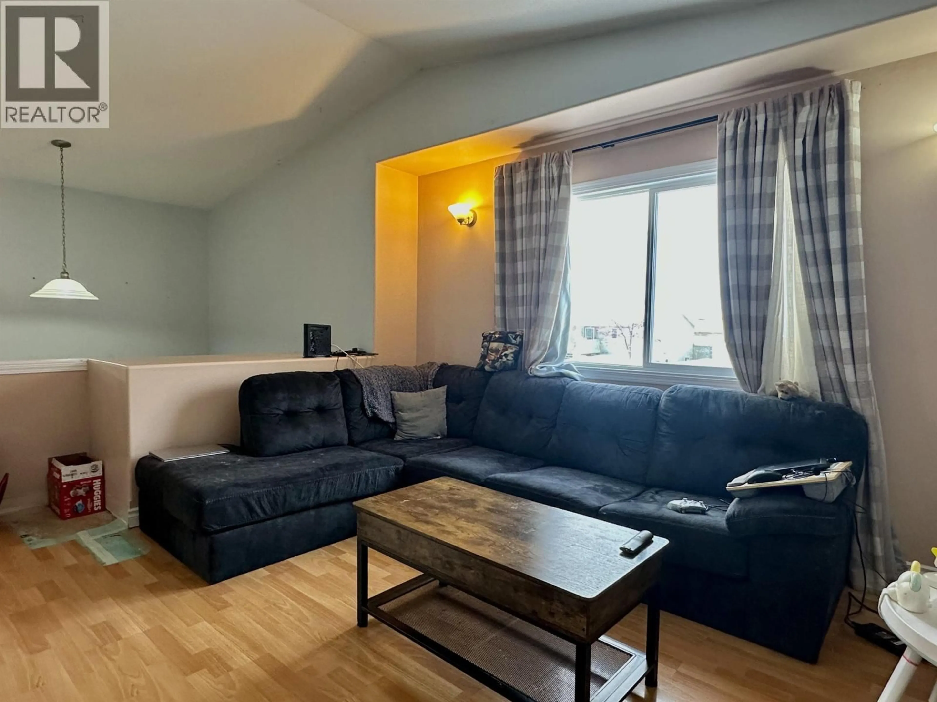 Living room with furniture, wood/laminate floor for 4405 HERITAGE CRESCENT, Fort Nelson British Columbia V0C1R0