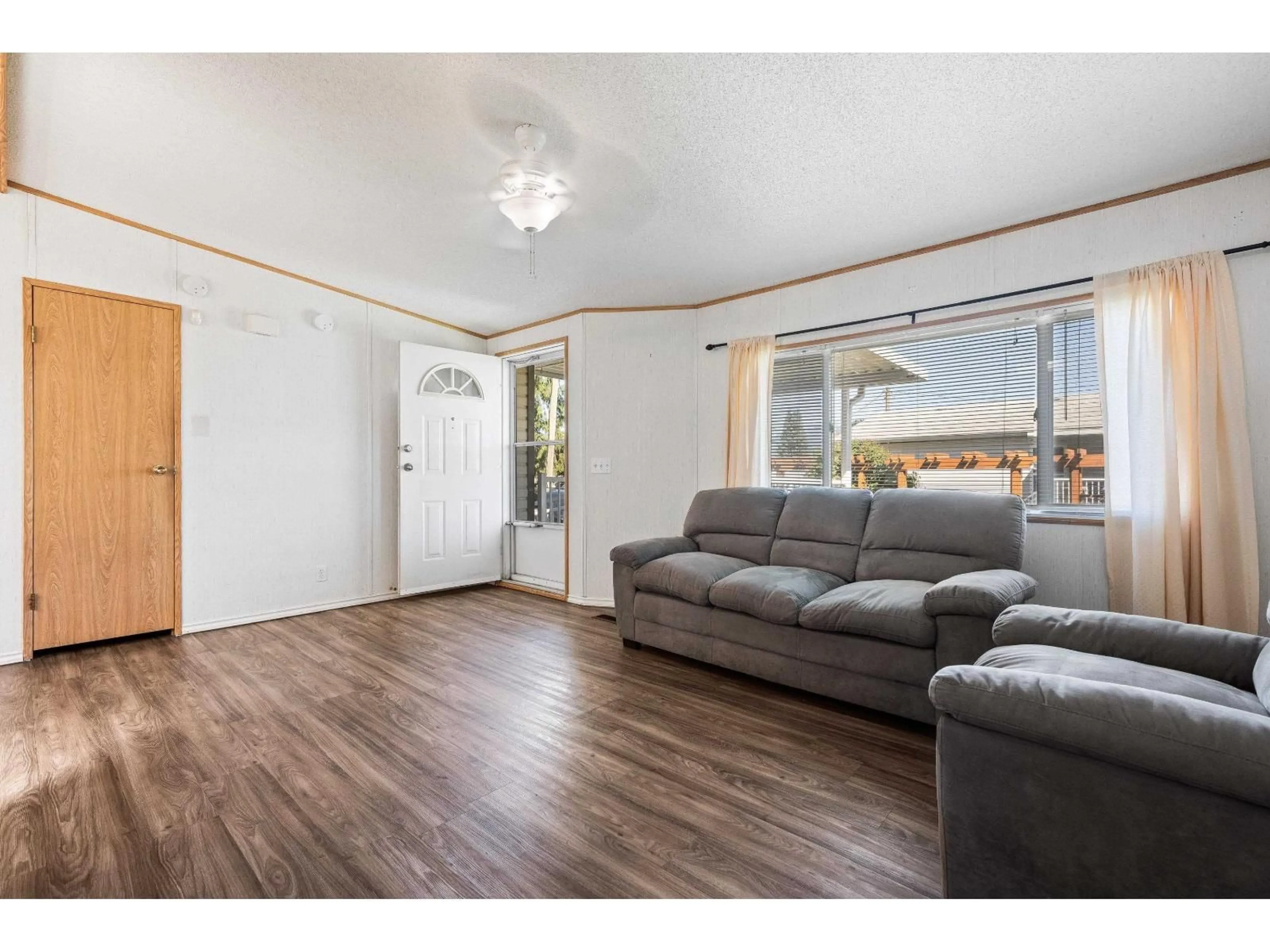 Living room with furniture, wood/laminate floor for 108 - 6035 VEDDER ROAD, Chilliwack British Columbia V2R1C5