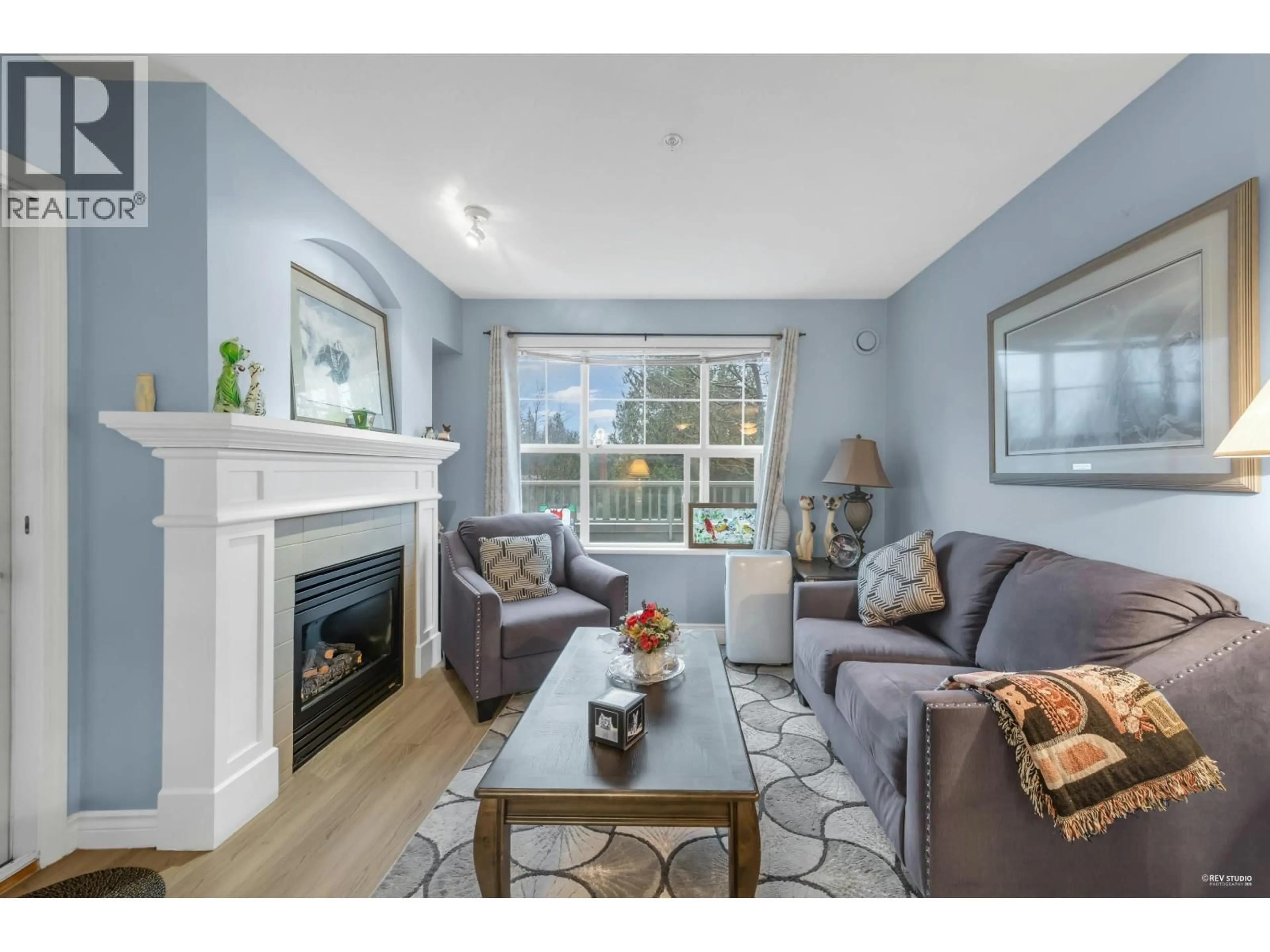 Living room with furniture, wood/laminate floor for 202 - 960 LYNN VALLEY ROAD, North Vancouver British Columbia V7J3V6