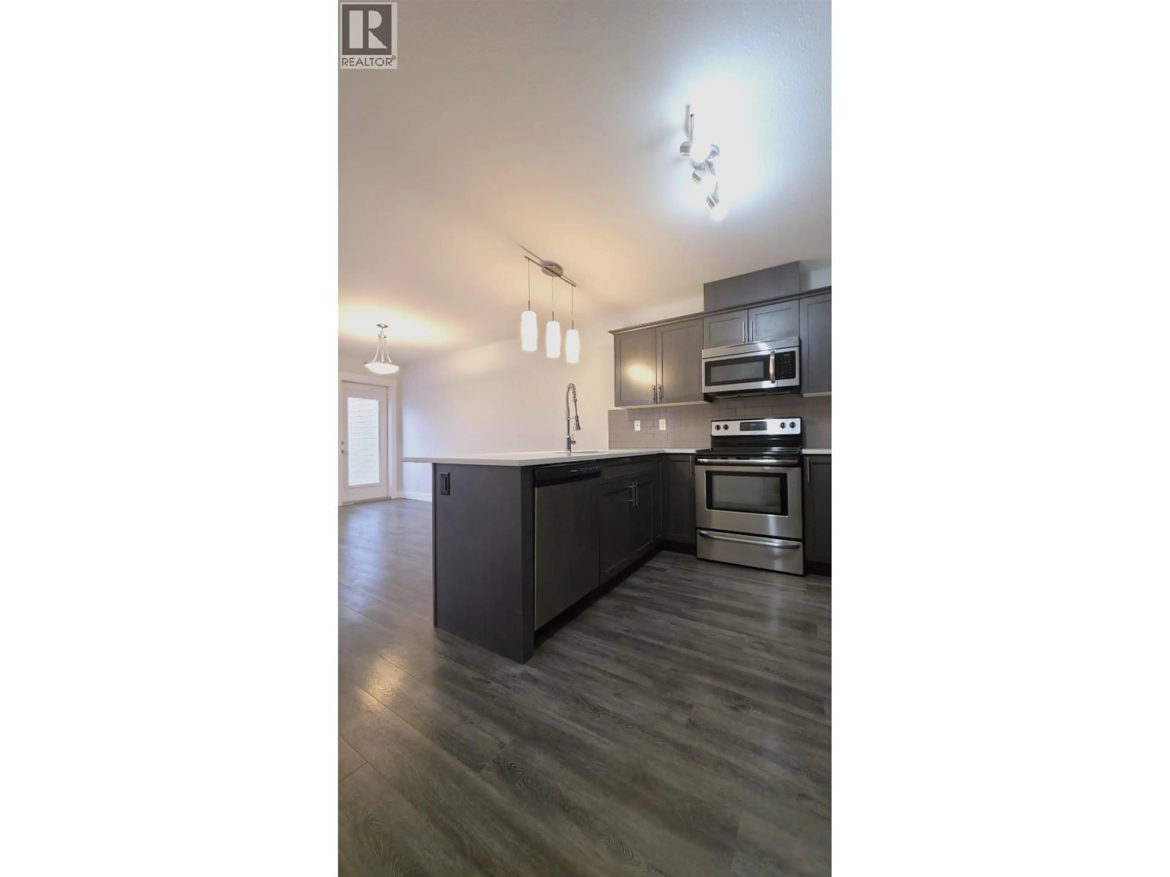 Open concept kitchen, wood/laminate floor for 101 - 6798 WESTGATE AVENUE, Prince George British Columbia V2N0H6